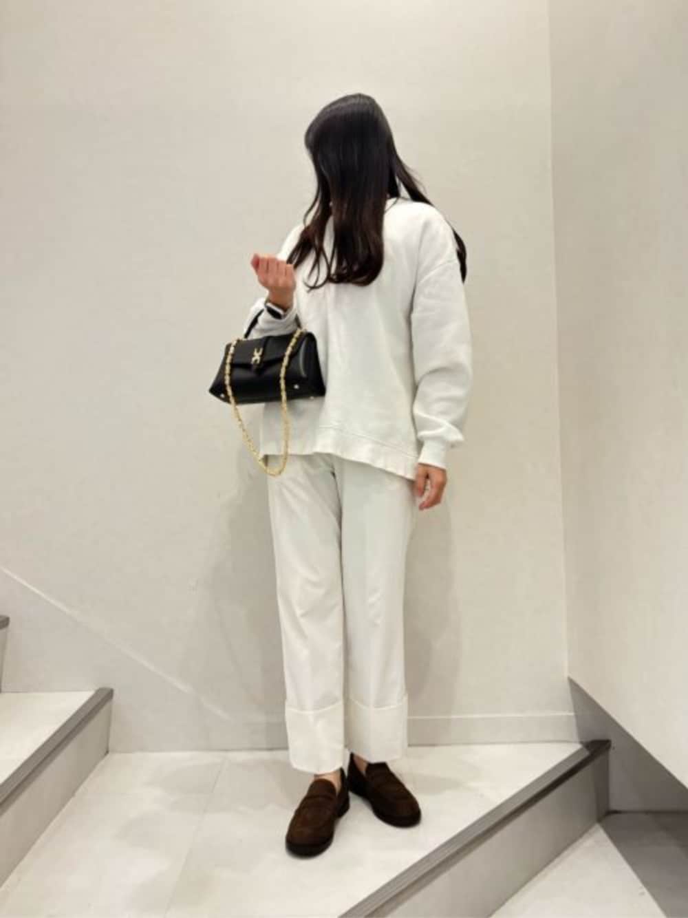 ブラック系のハンドバッグ、ブラウン系のローファーを着用したレディースの秋コーディネートの1枚目の写真