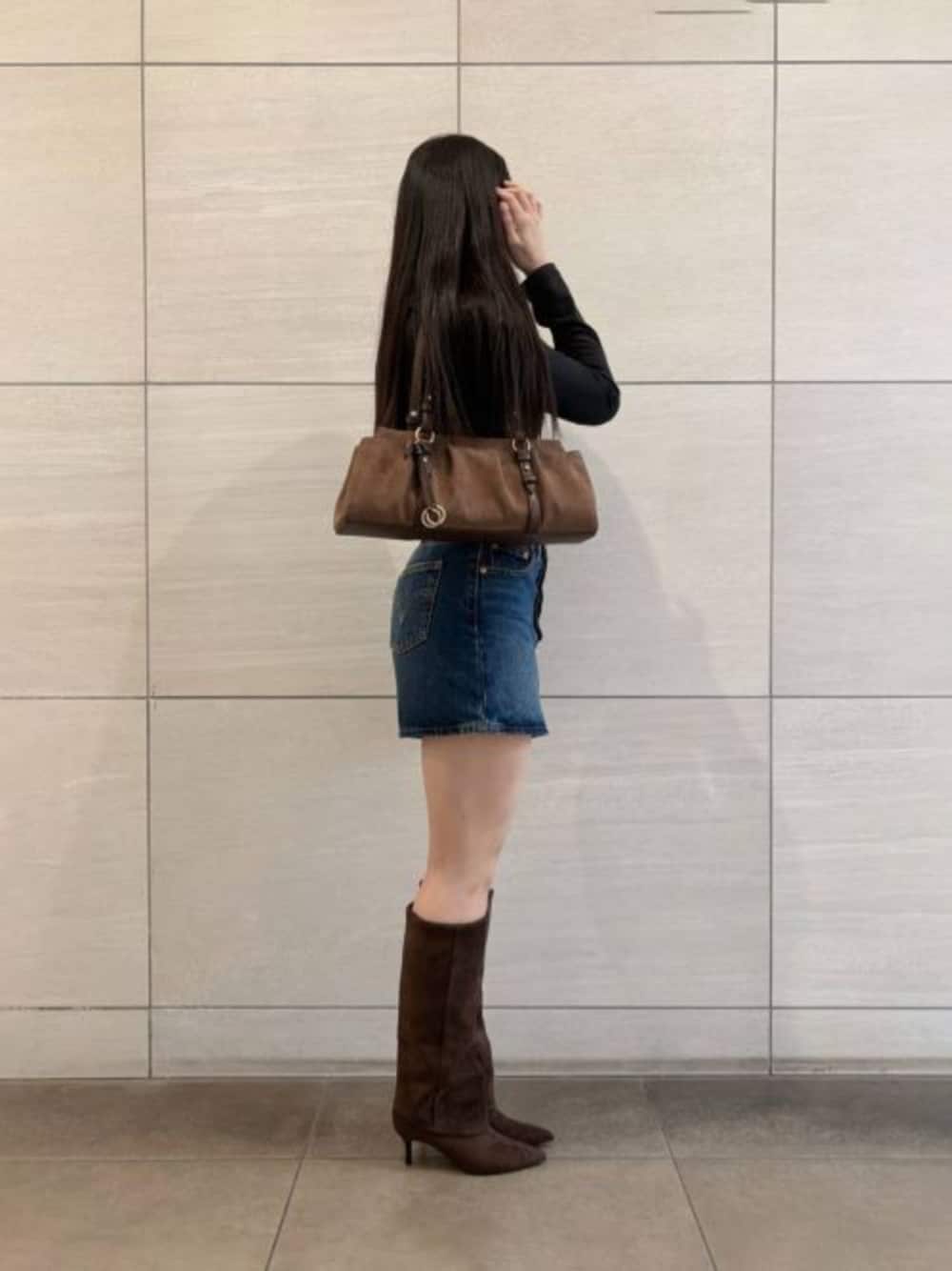 ブラウン系のトートバッグ、ブラウン系のブーツを着用したレディースの秋コーディネートの1枚目の写真