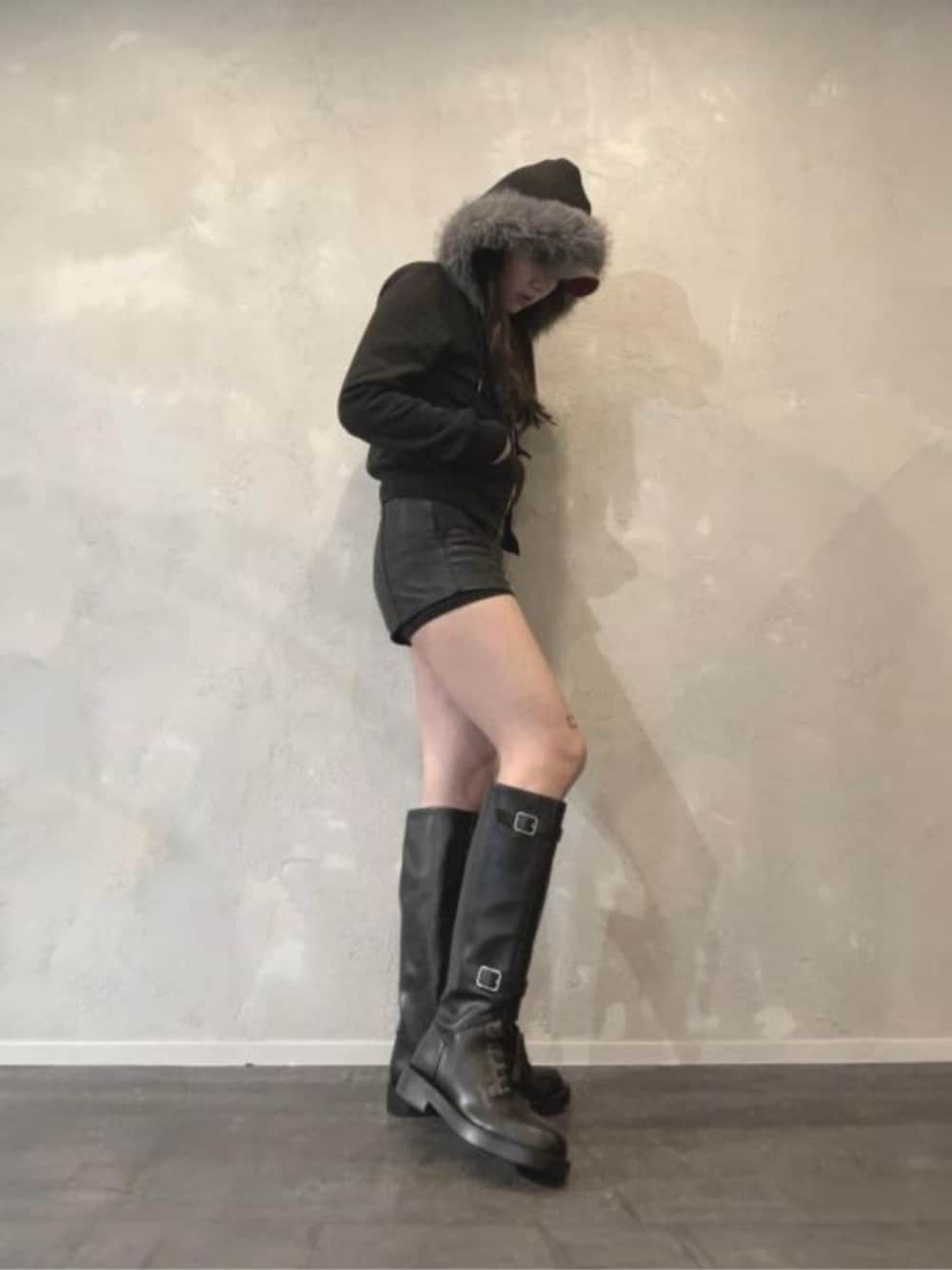 ブラック系のブーツを着用したレディースの秋コーディネートの1枚目の写真