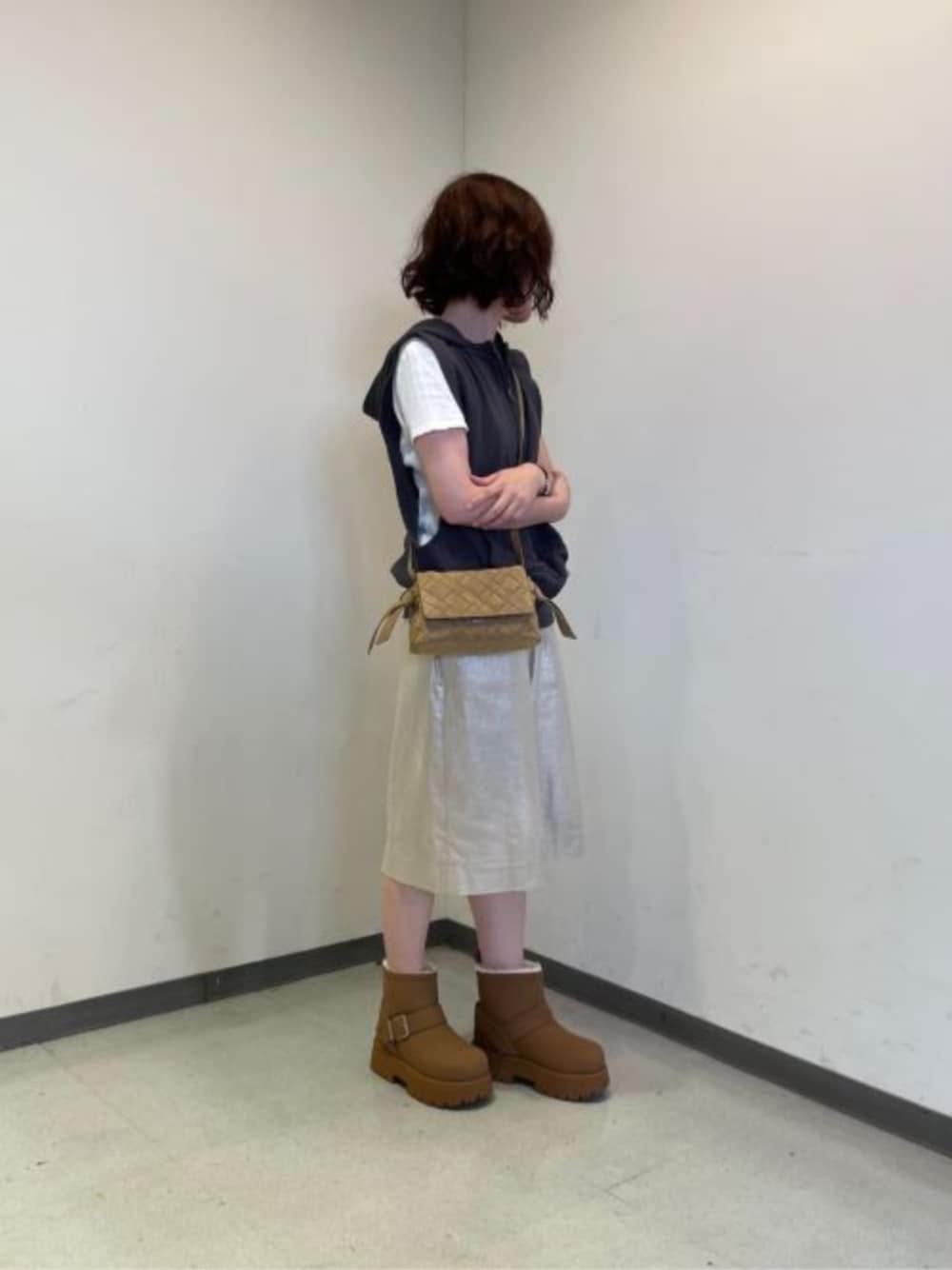 ベージュ系のショルダーバッグ、ブラウン系のブーツを着用したレディースの秋コーディネートの1枚目の写真