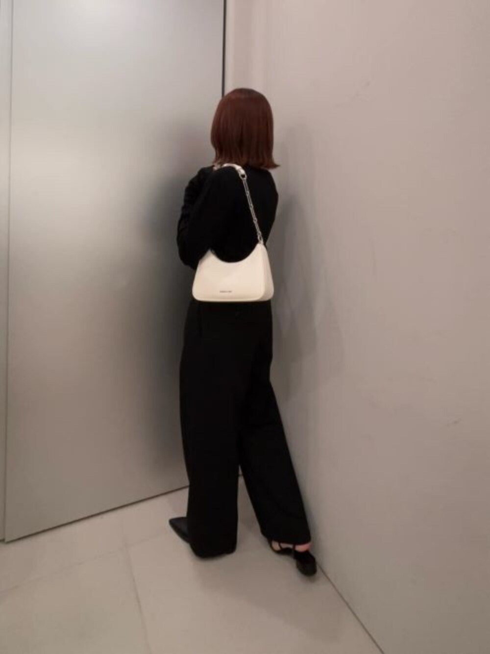 ベージュ系のショルダーバッグ、ブラック系のパンプスを着用したレディースの春コーディネートの1枚目の写真
