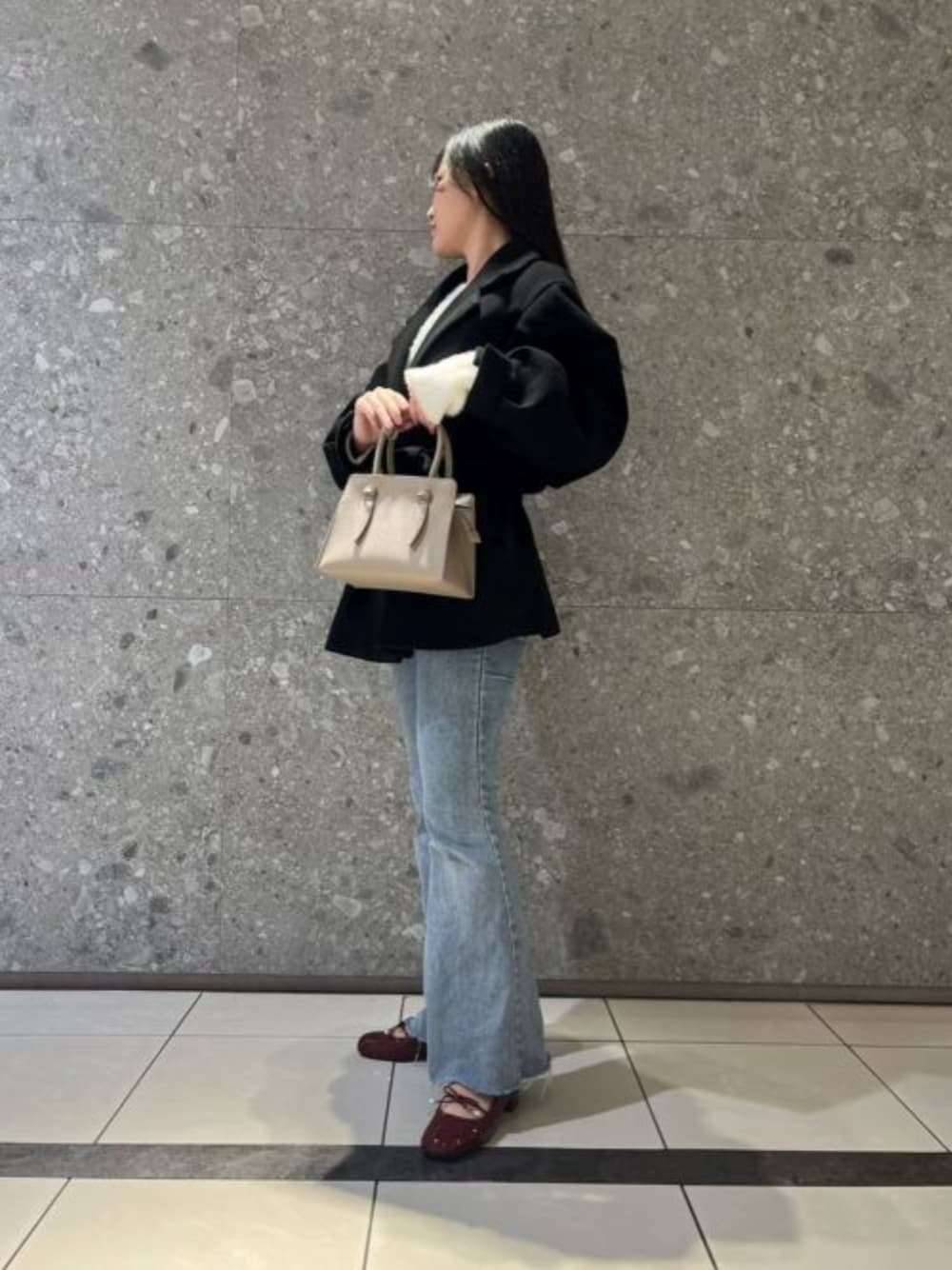 ベージュ系のトートバッグ、レッド系のパンプスを着用したレディースの冬コーディネートの1枚目の写真