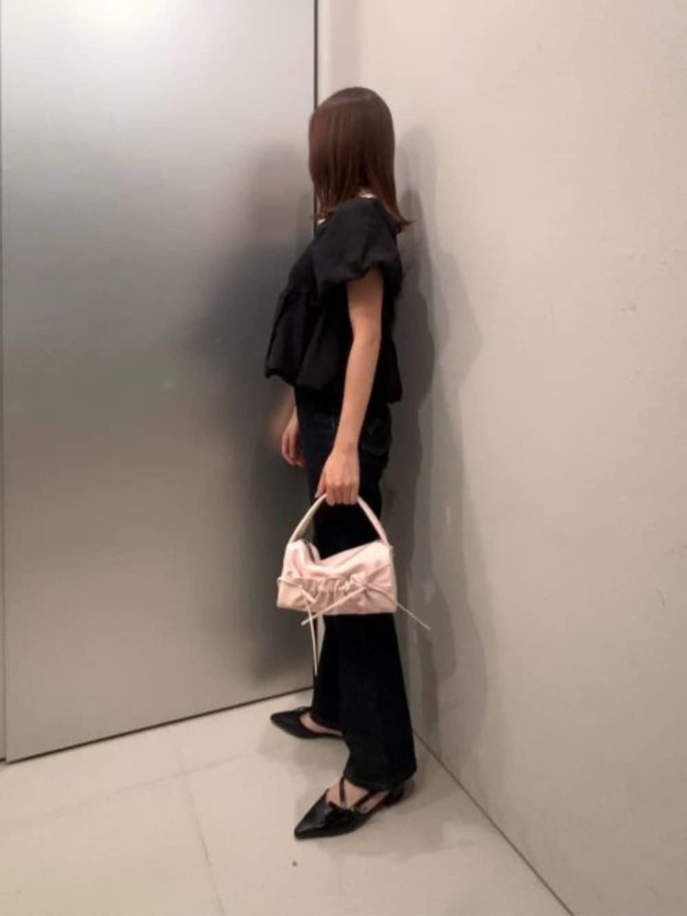 ピンク系のハンドバッグ、ブラック系のパンプスを着用したレディースの夏コーディネートの1枚目の写真