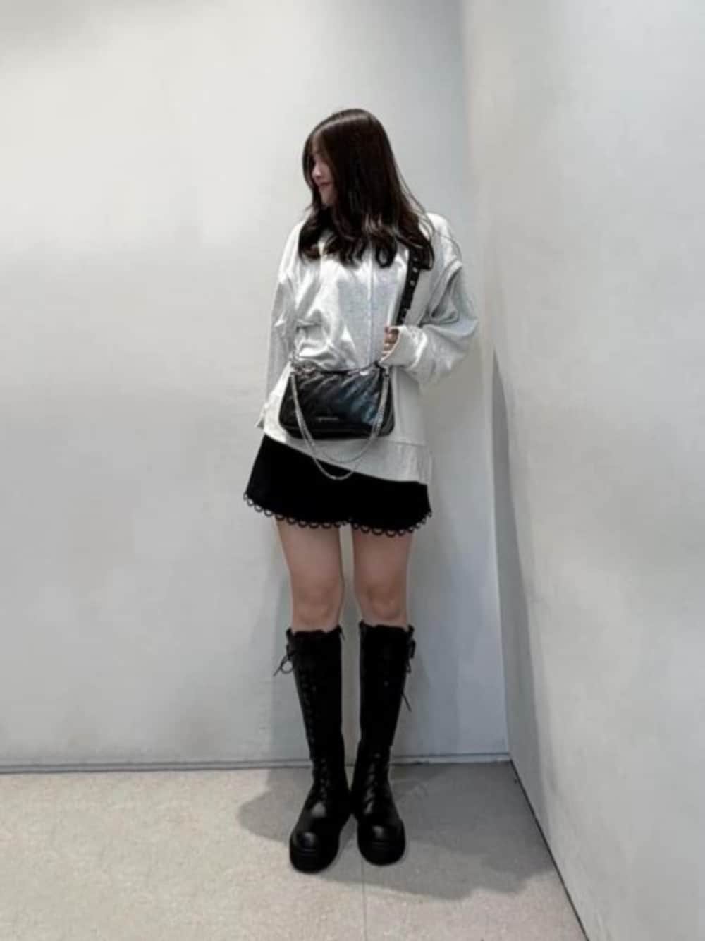 ブラック系のボディバッグ/ウエストポーチ、ブラック系のブーツを着用したレディースの秋コーディネートの1枚目の写真