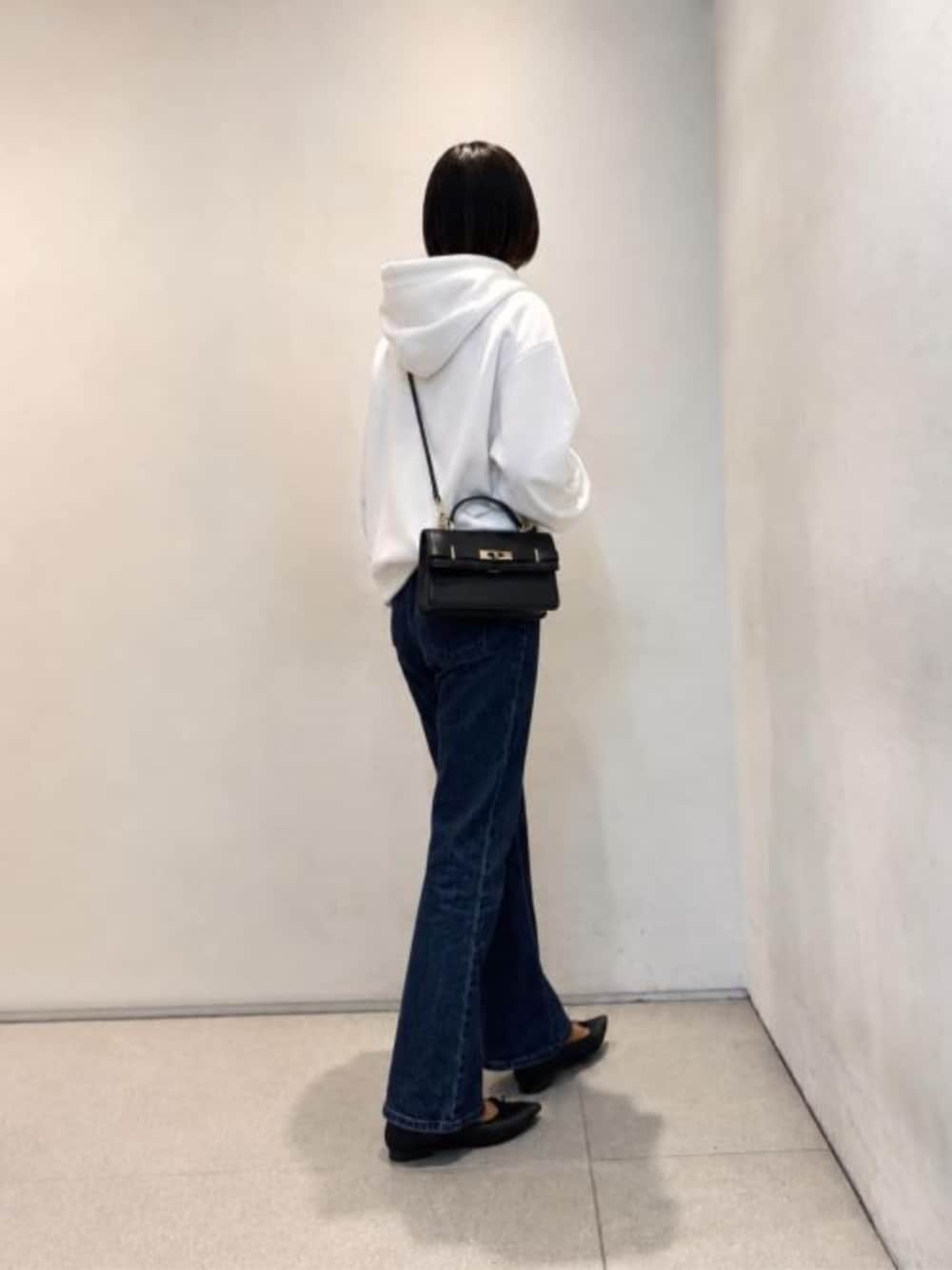 ブラック系のハンドバッグ、ブラック系のバレエシューズを着用したレディースの春コーディネートの1枚目の写真