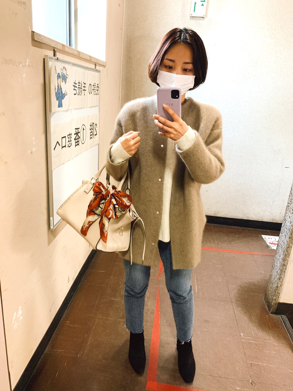 ベージュ系のジャケット/アウター、ホワイト系のニット/セーター、グレー系のデニムパンツを着用したレディースの冬コーディネートの1枚目の写真