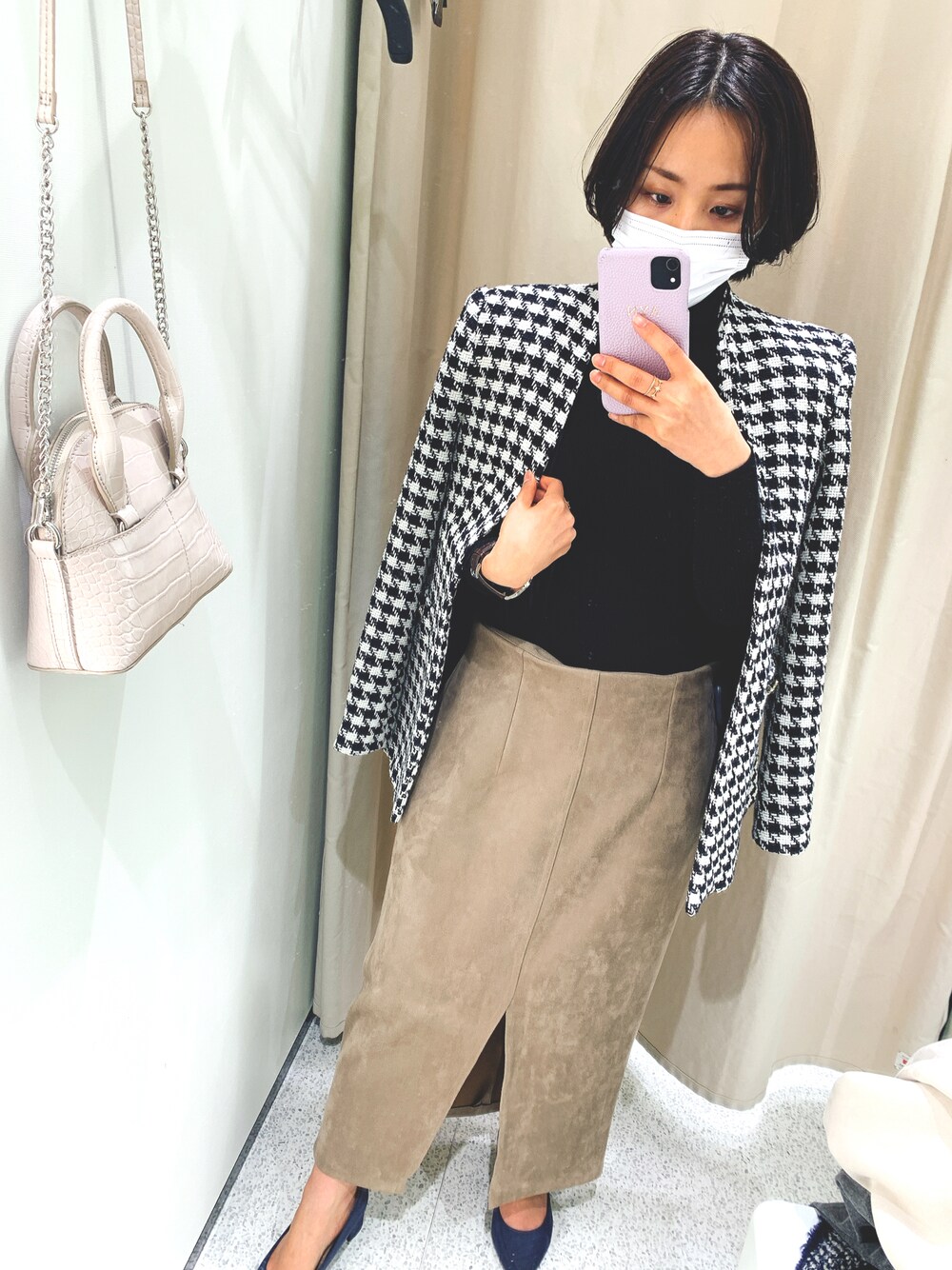 ブラック系のニット/セーター、ブラック系のジャケット/アウター、ベージュ系のスカートを着用したレディースの秋コーディネートの1枚目の写真