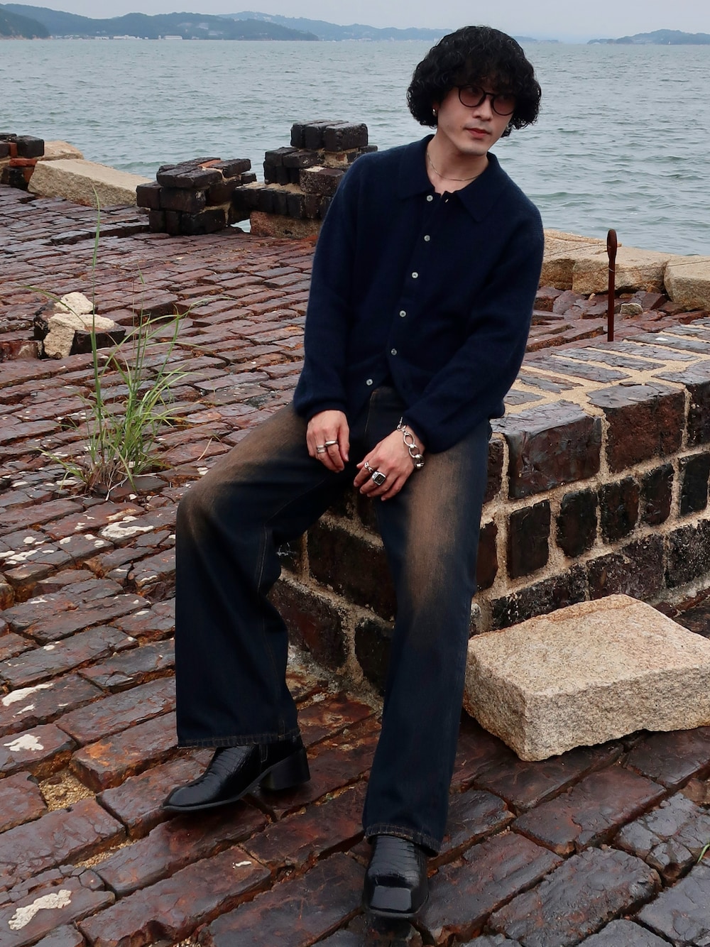 その他のデニムパンツ、ブルー系のニット/セーター、その他のブーツを着用したメンズの秋コーディネートの1枚目の写真