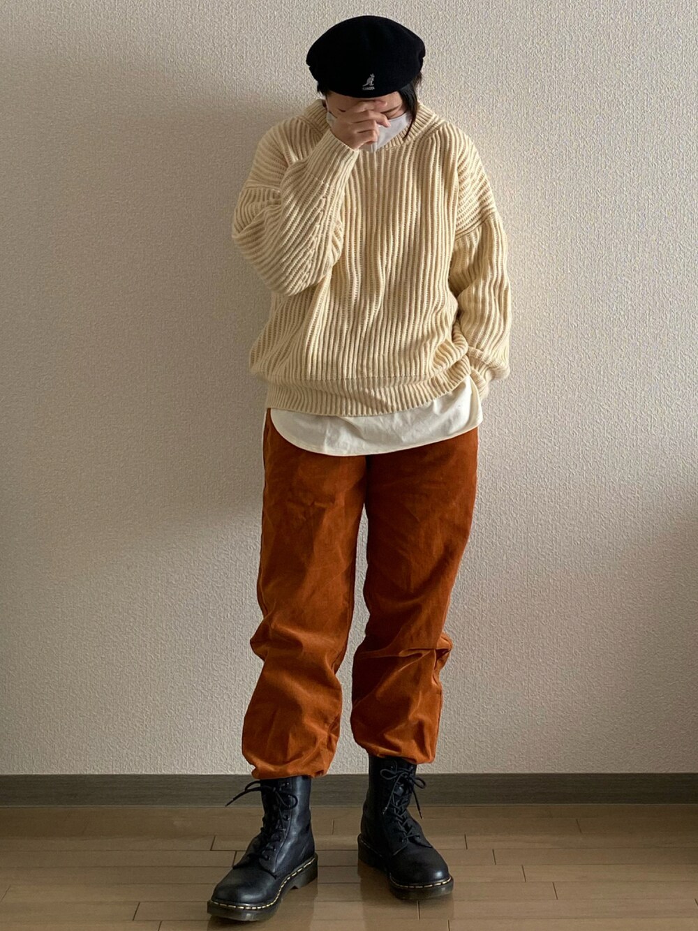 ブラック系のブーツ、ベージュ系のニット/セーター、ホワイト系のTシャツ/カットソーを着用したレディースの秋コーディネートの1枚目の写真
