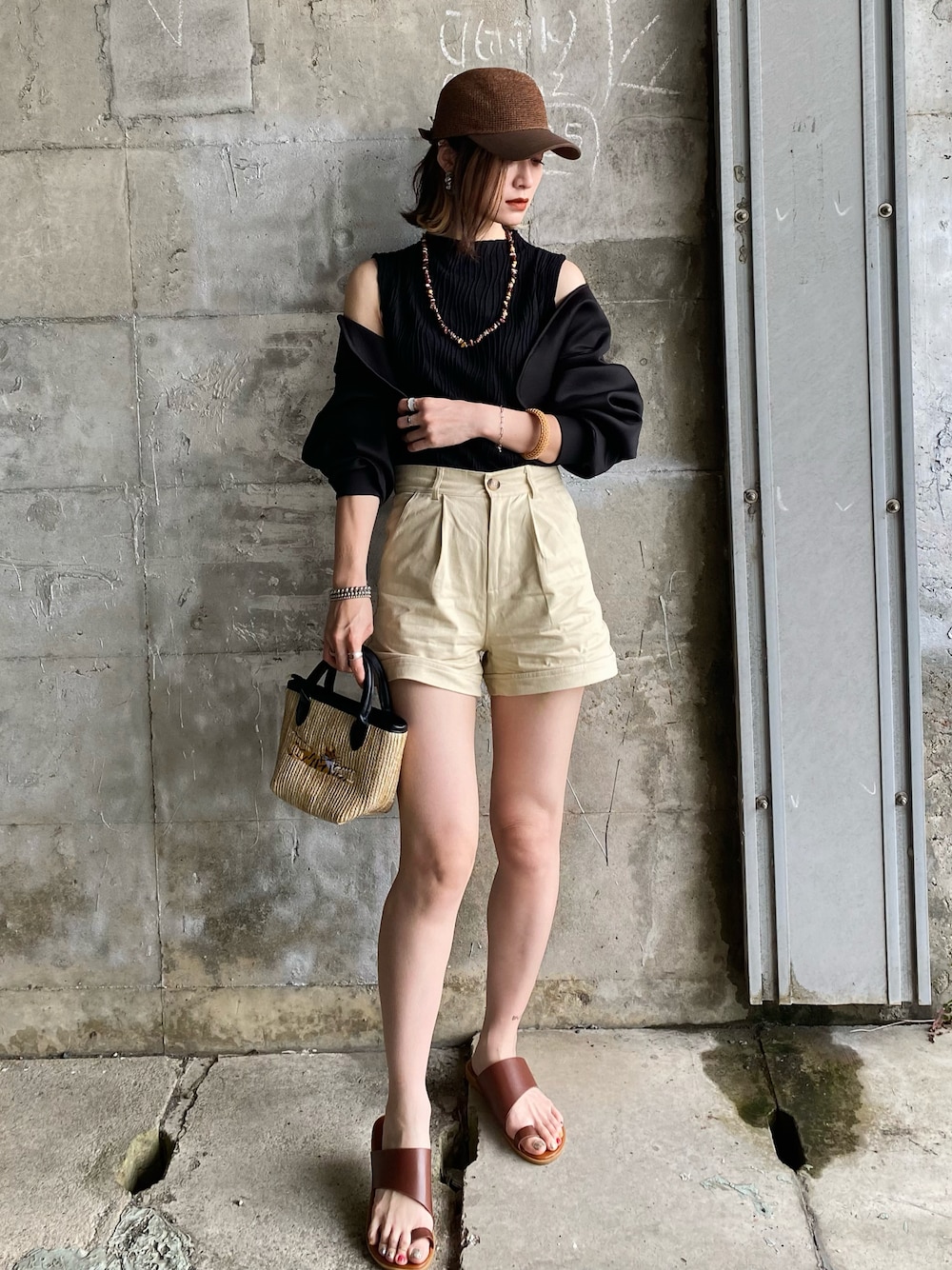 ブラック系のカーディガン/ボレロ、ベージュ系のチノパンツ、ブラウン系のサンダルを着用したレディースの春コーディネートの1枚目の写真