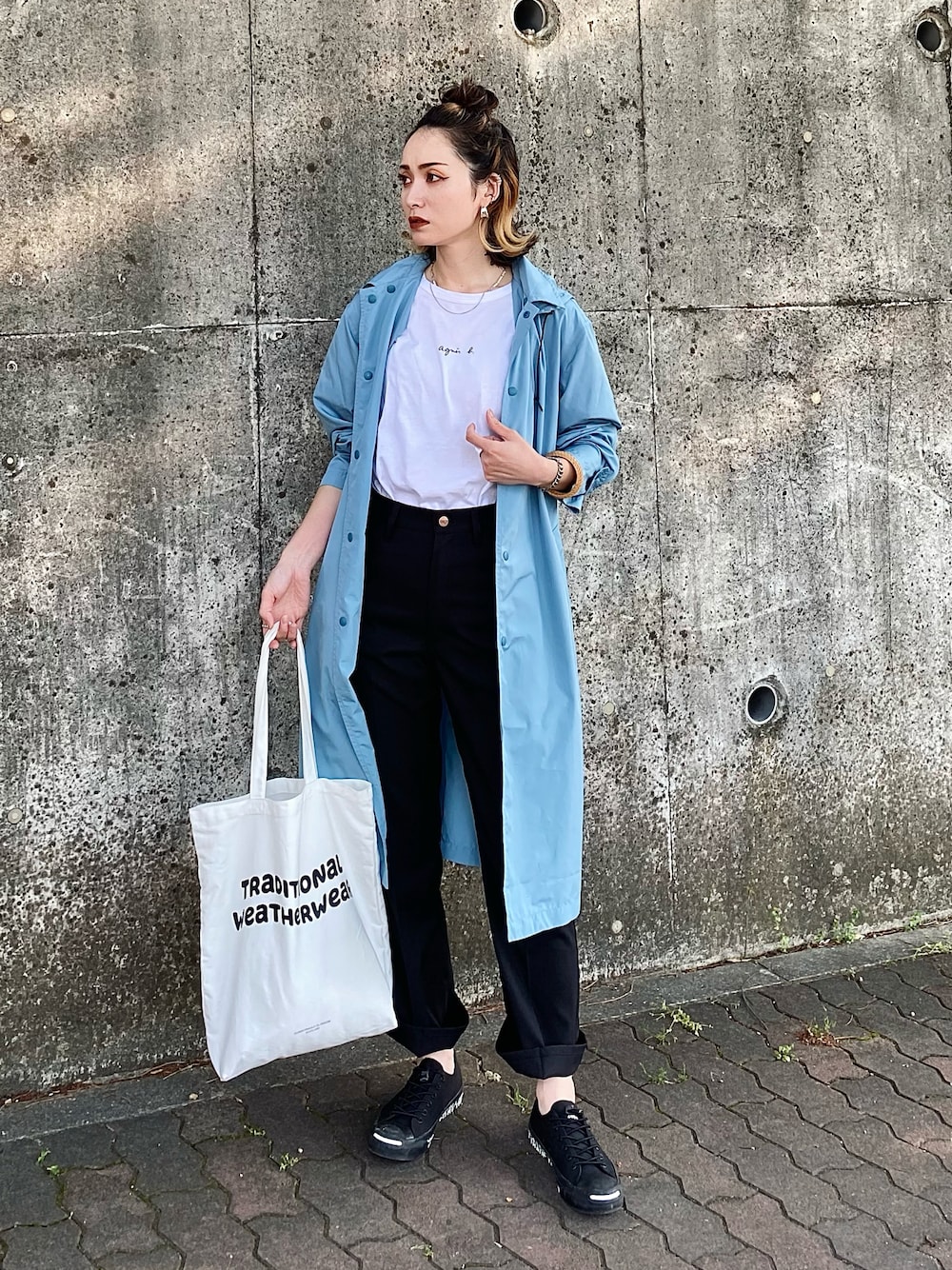 ホワイト系のトートバッグ、ホワイト系のTシャツ/カットソー、ブラック系のスラックスを着用したレディースの春コーディネートの1枚目の写真