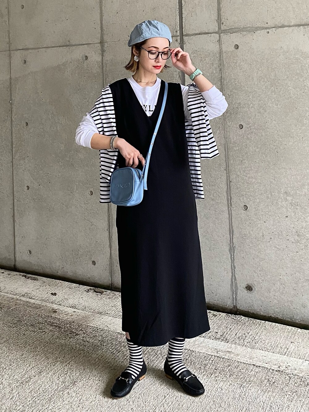ブラック系のローファー、ブラック系のワンピース、ホワイト系のTシャツ/カットソーを着用したレディースの春コーディネートの1枚目の写真