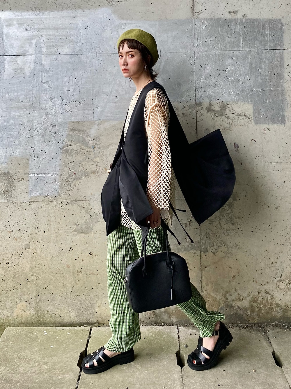 ブラック系のベスト、グリーン系のその他パンツ、ブラック系のサンダルを着用したレディースの春コーディネートの1枚目の写真