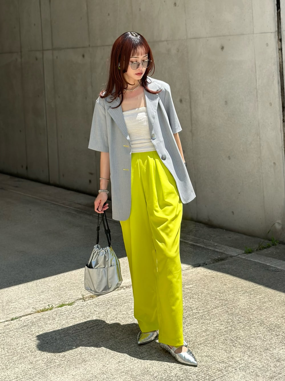 グレー系のテーラードジャケット、ホワイト系のチューブトップ、シルバー系のハンドバッグを着用したレディースの夏コーディネートの1枚目の写真