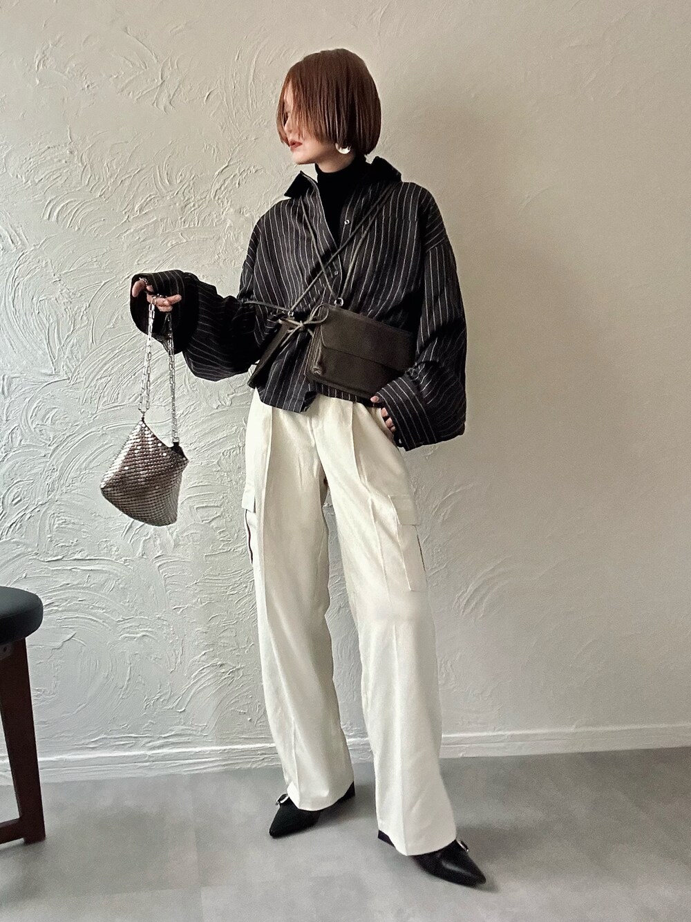 グレー系のシャツ/ブラウス、ホワイト系のカーゴパンツ、グレー系のハンドバッグを着用したレディースの冬コーディネートの1枚目の写真