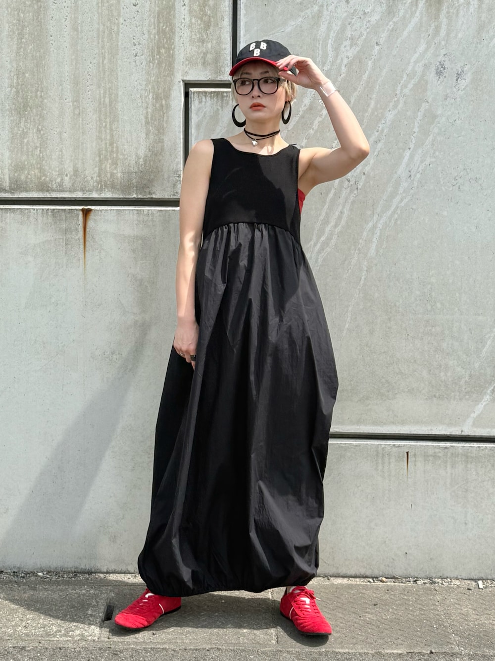 ブラック系のワンピース、レッド系のキャミソール、レッド系のスニーカーを着用したレディースの春コーディネートの1枚目の写真