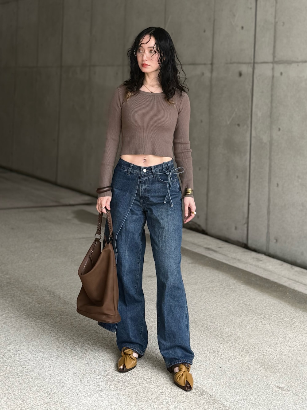 ブラウン系のショルダーバッグ、イエロー系のサンダル、グリーン系のニット/セーターを着用したレディースの春コーディネートの1枚目の写真