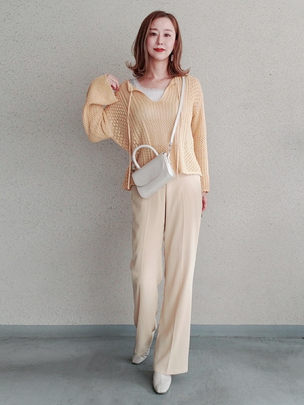 ベージュ系のその他パンツ、イエロー系のトップスを着用したレディースの春コーディネートの2枚目の写真