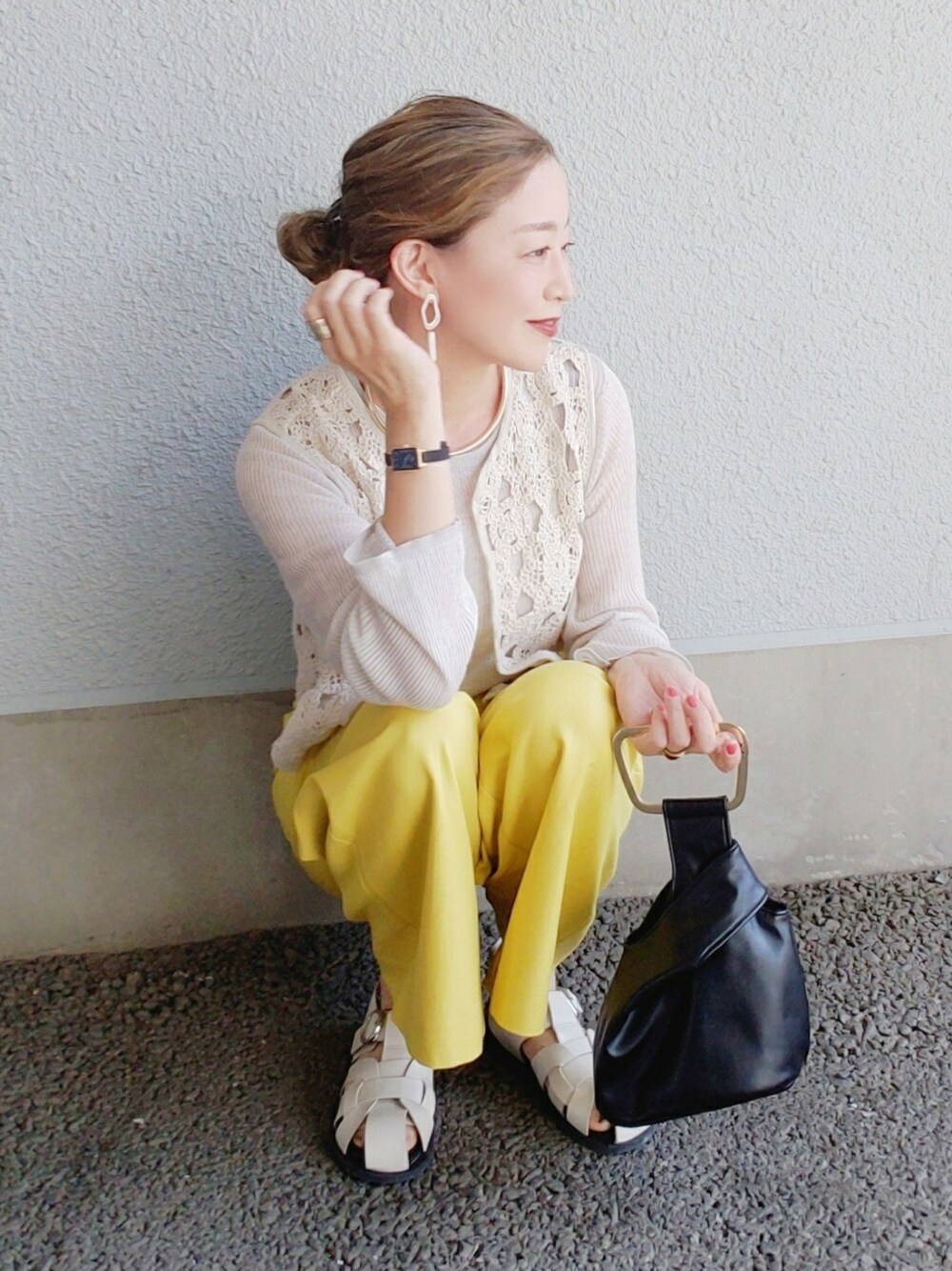 イエロー系のその他パンツ、ブラック系のベスト、ホワイト系のサンダルを着用したレディースの春コーディネートの5枚目の写真