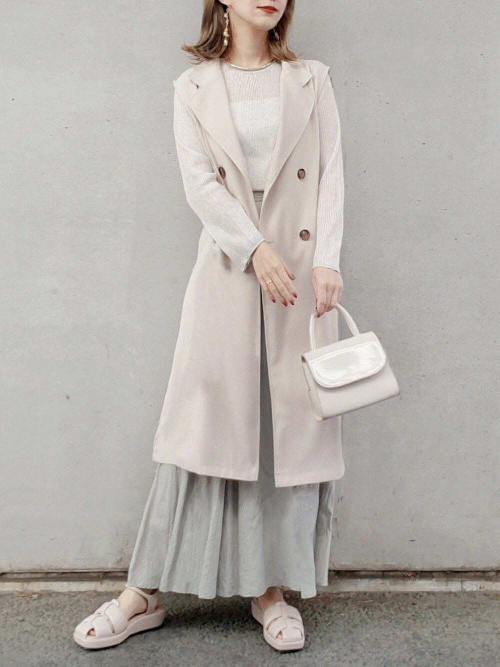 グリーン系のスカート、ベージュ系のニット/セーター、ベージュ系のサンダルを着用したレディースの春コーディネートの4枚目の写真