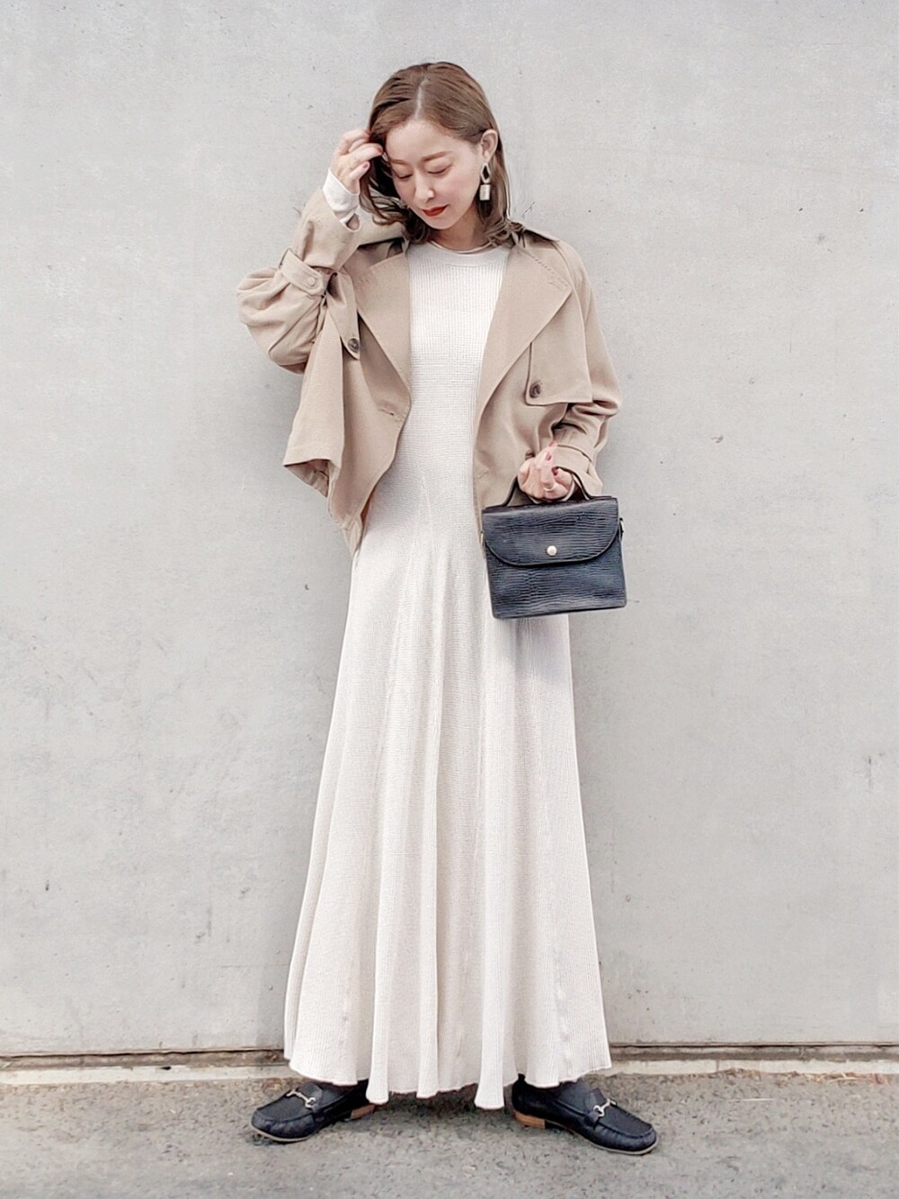 ベージュ系のその他アウター、ホワイト系のワンピース、ブラック系のショルダーバッグを着用したレディースの春コーディネートの2枚目の写真