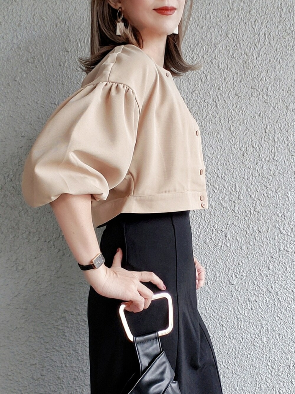 ブラック系のスカート、ベージュ系のシャツ/ブラウス、ブラック系のブーツを着用したレディースの春コーディネートの2枚目の写真