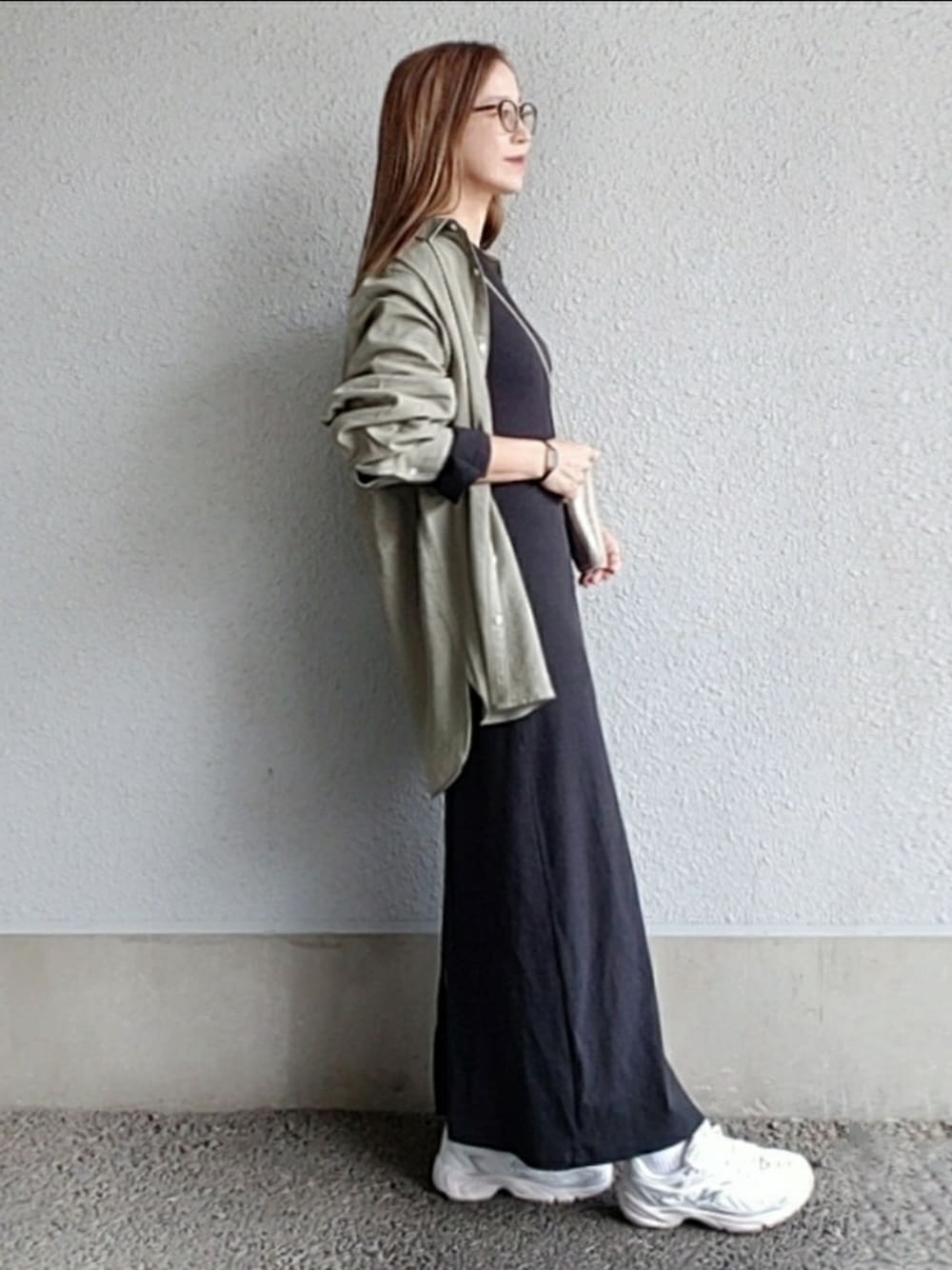 グリーン系のシャツ/ブラウス、ブラック系のワンピース、ベージュ系のスニーカーを着用したレディースの春コーディネートの1枚目の写真