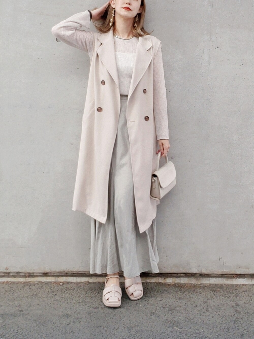 グリーン系のスカート、ベージュ系のニット/セーター、ベージュ系のサンダルを着用したレディースの春コーディネートの3枚目の写真