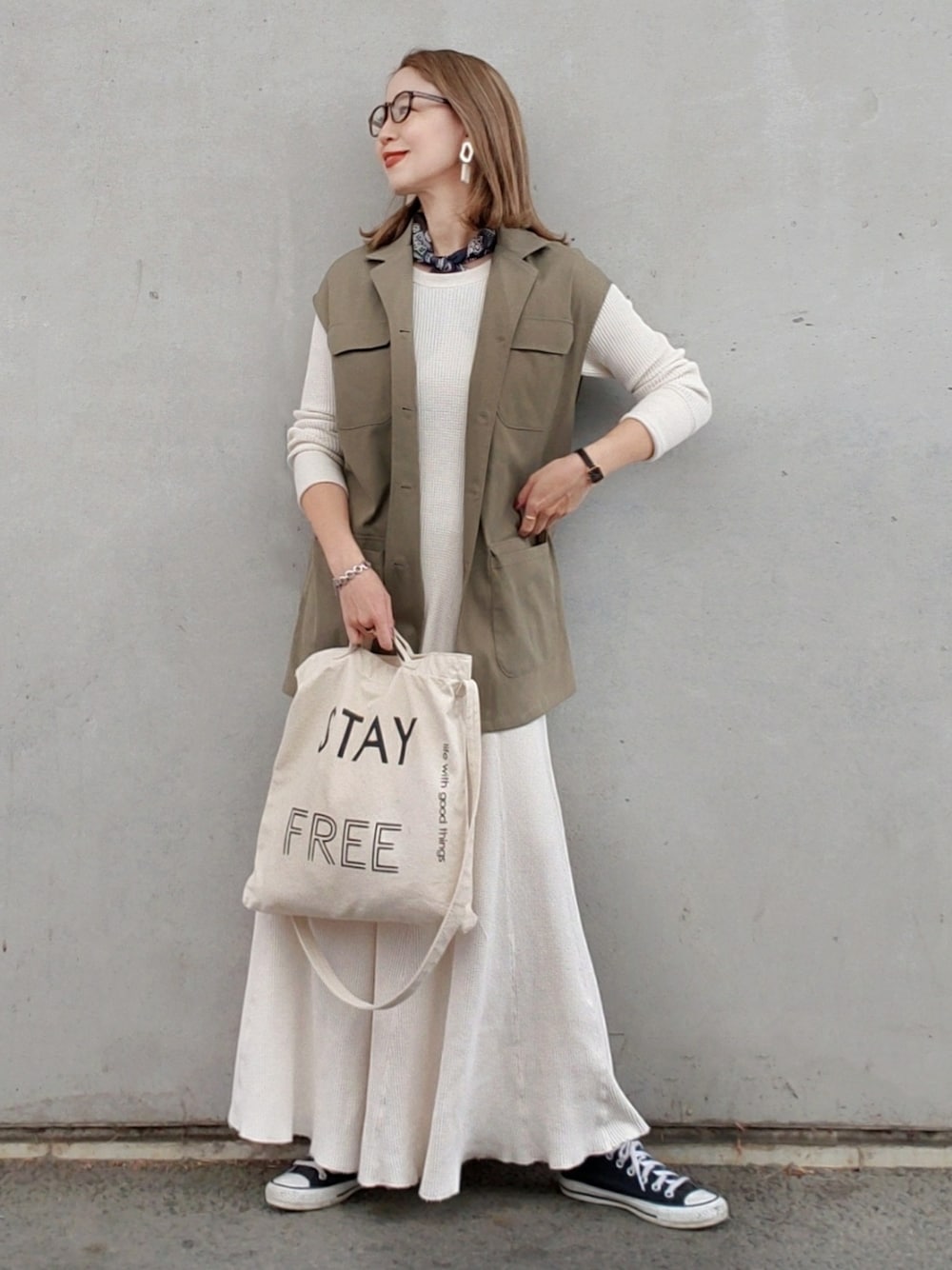 グリーン系のベスト、ホワイト系のワンピース、ホワイト系のトートバッグを着用したレディースの春コーディネートの2枚目の写真