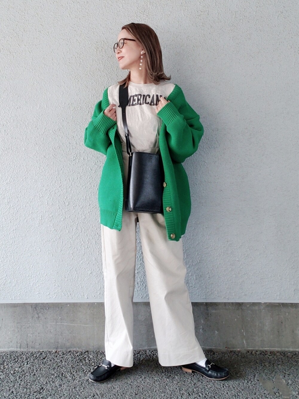 ベージュ系のTシャツ/カットソー、グリーン系のカーディガン/ボレロ、ベージュ系のその他パンツを着用したレディースの春コーディネートの3枚目の写真