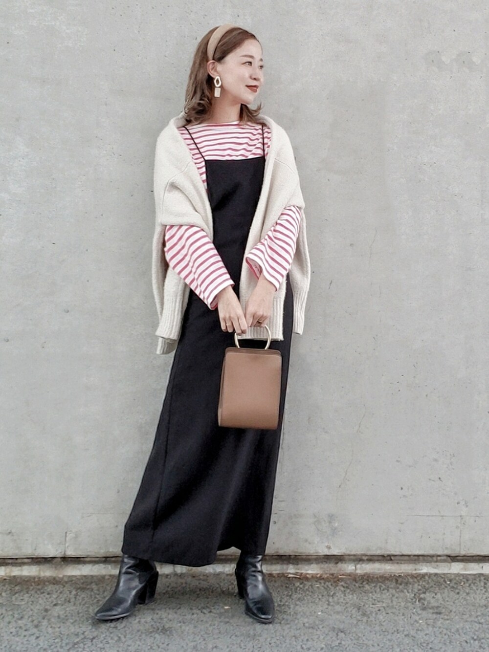 ピンク系のTシャツ/カットソー、ブラック系のワンピース、ブラック系のブーツを着用したレディースの冬コーディネートの3枚目の写真