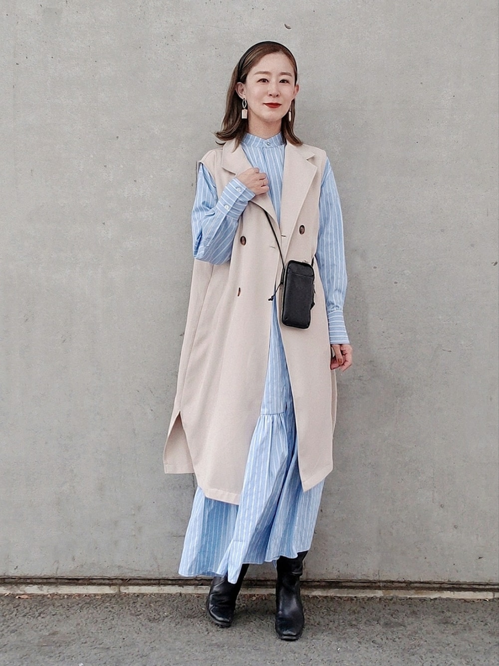 ブルー系のシャツワンピース、ブラック系のブーツ、ブラック系の財布を着用したレディースの春コーディネートの3枚目の写真