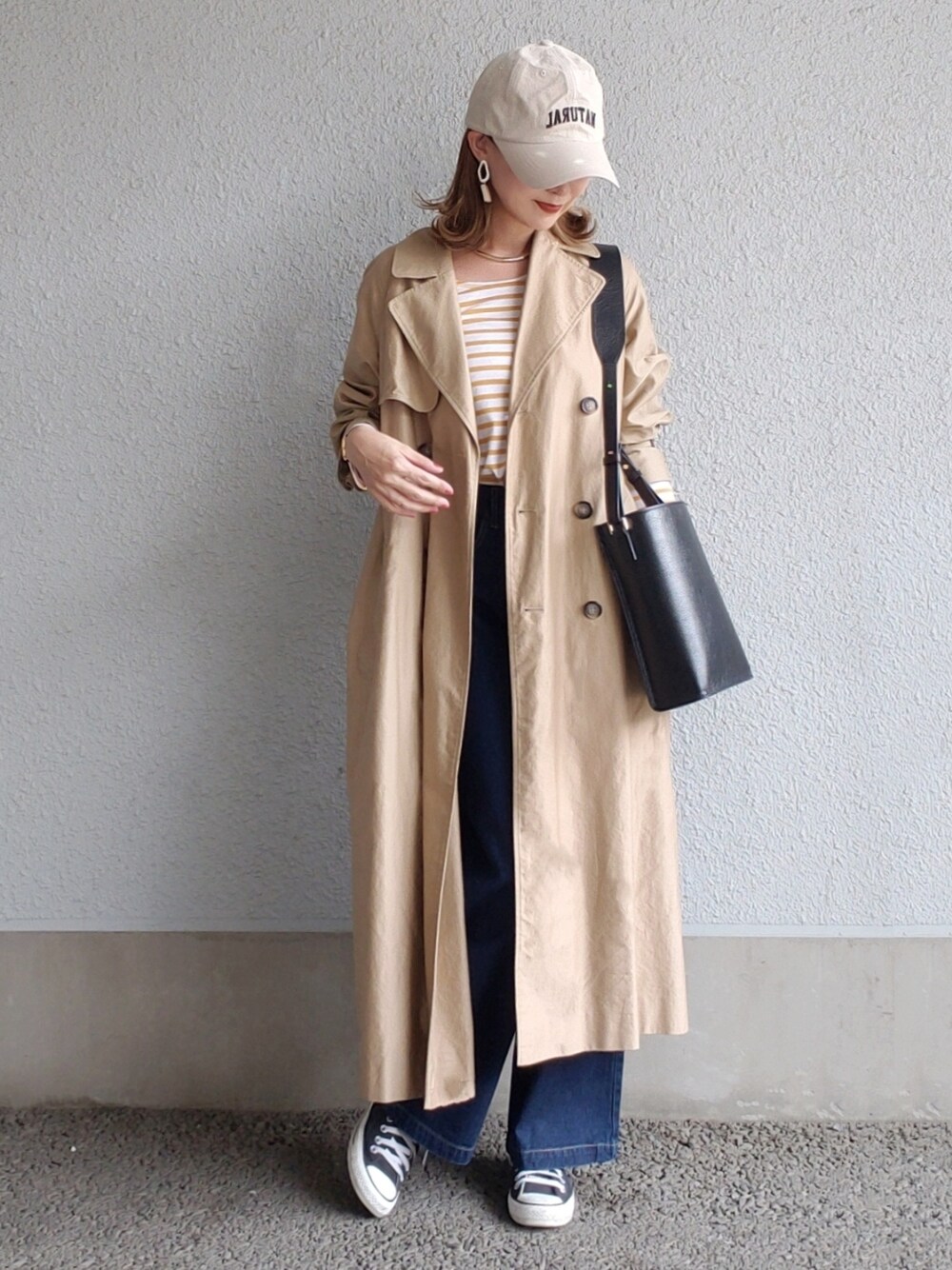 ベージュ系のトレンチコート、ブラック系のバッグ、ブラック系のスニーカーを着用したレディースの春コーディネートの3枚目の写真