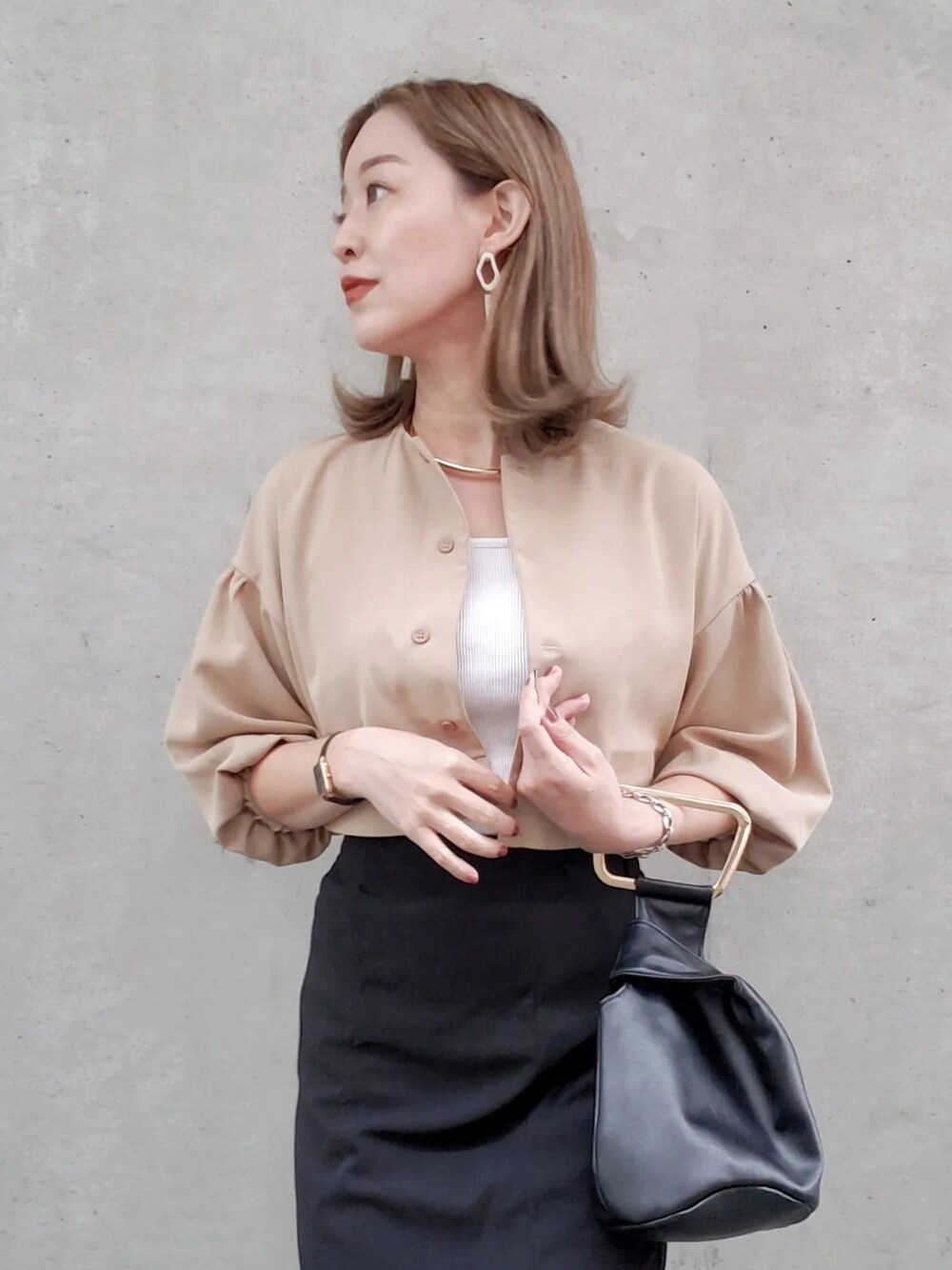 ブラック系のスカート、ベージュ系のシャツ/ブラウス、ブラック系のブーツを着用したレディースの春コーディネートの4枚目の写真