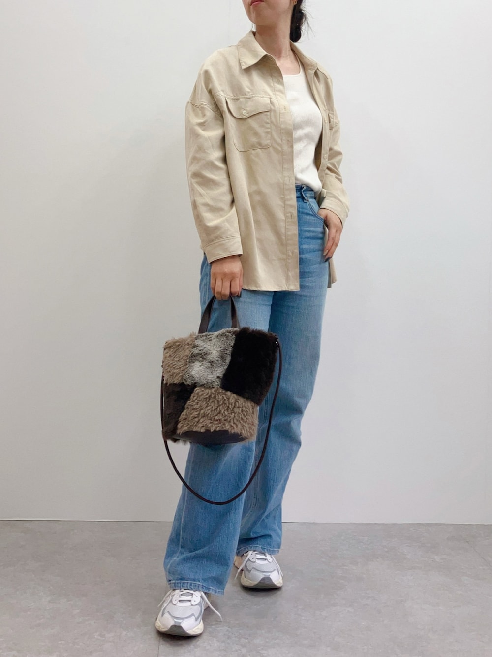 ブラウン系のトートバッグを着用したレディースの秋コーディネートの1枚目の写真