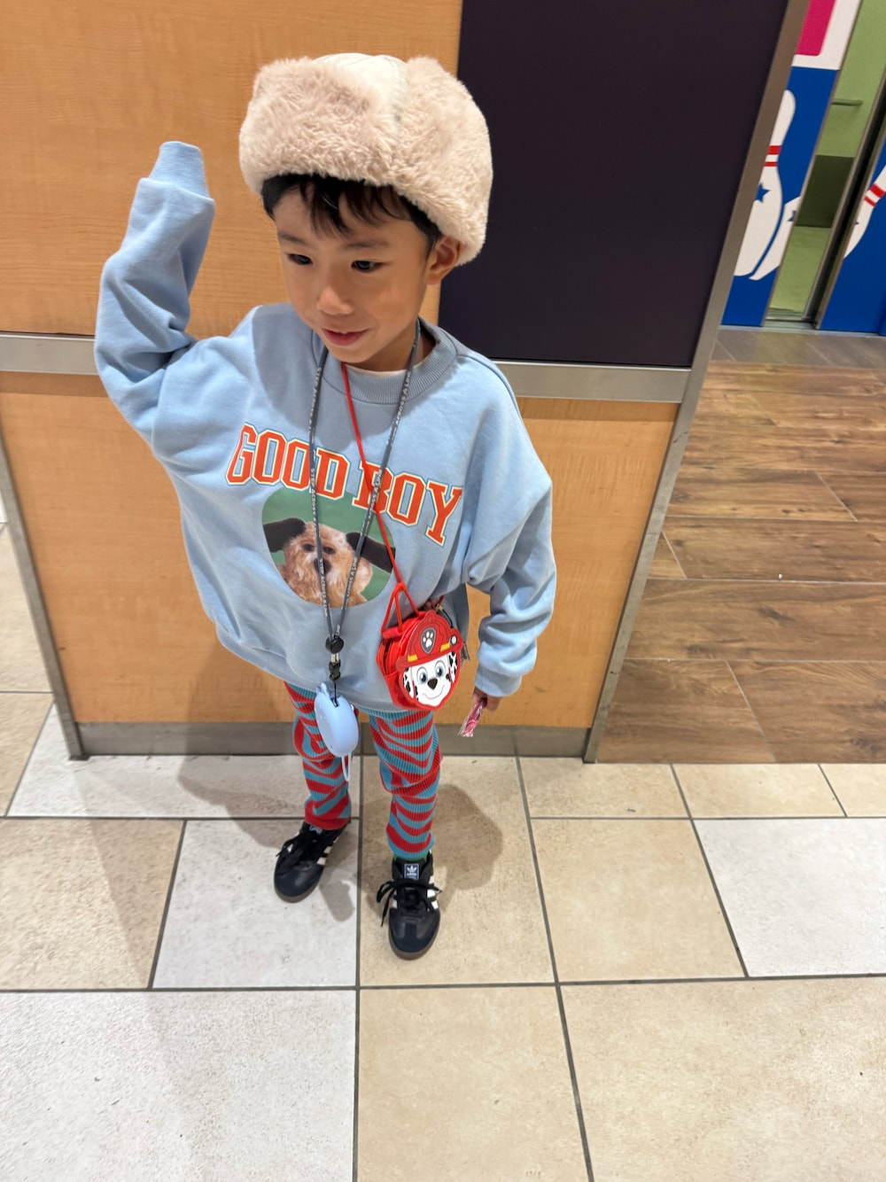 ブルー系のスウェット、ブラック系のスニーカー、ベージュ系のキャップを着用したキッズの秋コーディネートの1枚目の写真