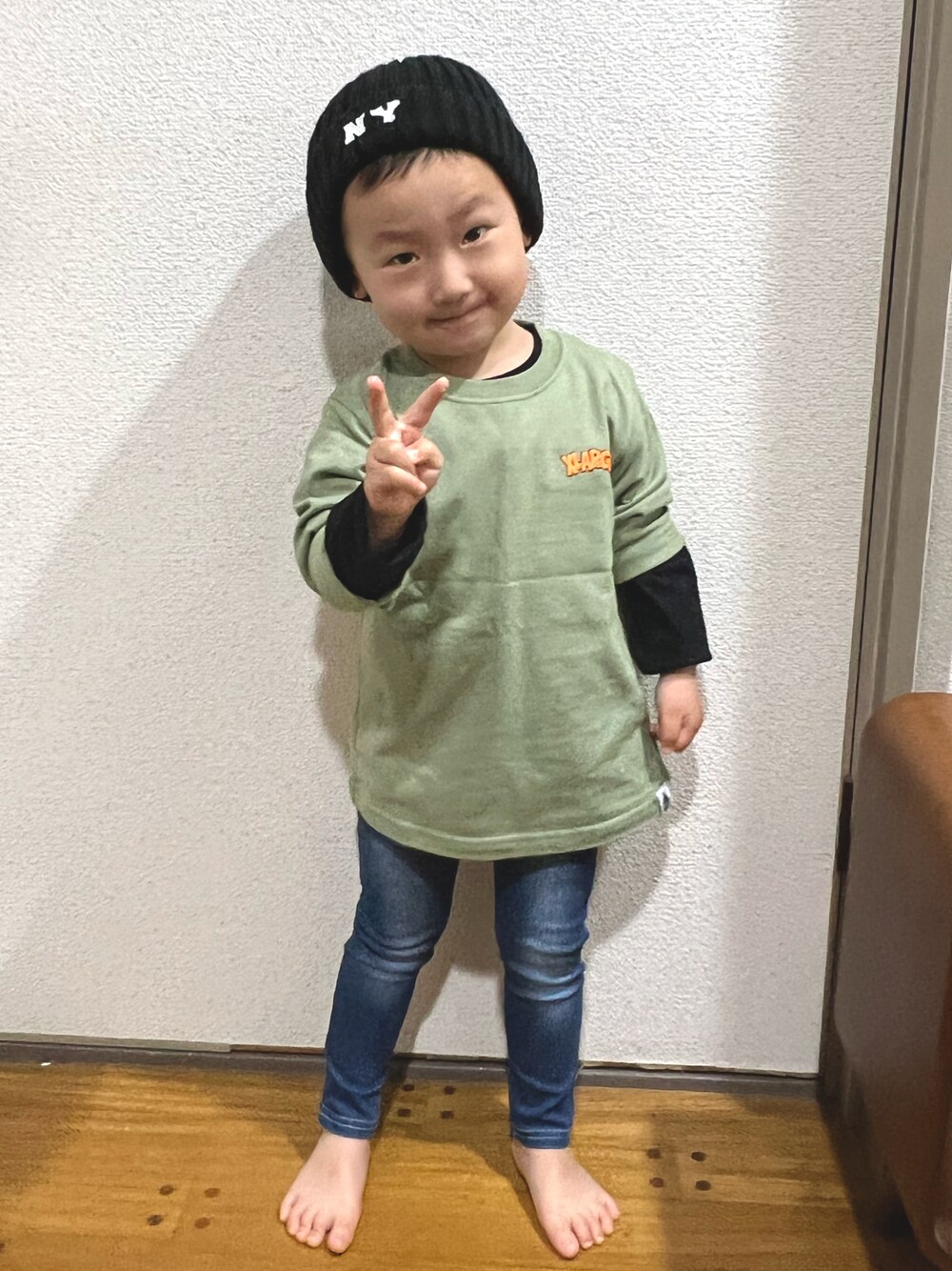 グリーン系のTシャツ/カットソー、ブラック系のニットキャップ/ビーニーを着用したキッズの春コーディネートの1枚目の写真