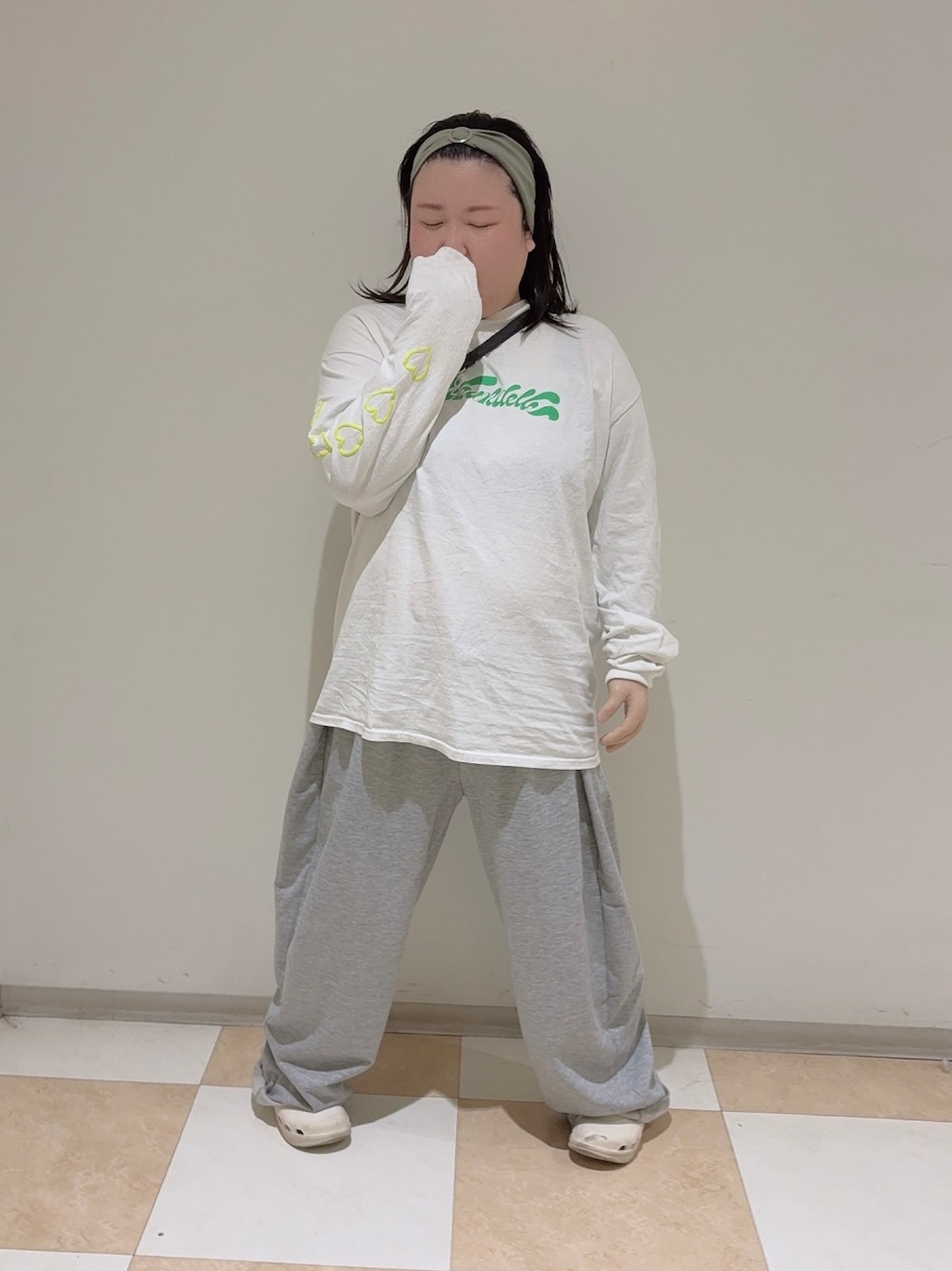 ホワイト系のTシャツ/カットソー、ホワイト系のサンダル、グリーン系のヘアバンドを着用したレディースの秋コーディネートの1枚目の写真