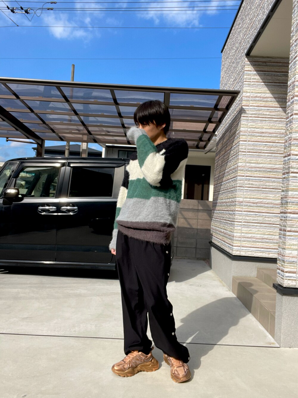 ブラック系のニット/セーター、ブラック系のその他パンツ、ゴールド系のスニーカーを着用したメンズの冬コーディネートの1枚目の写真