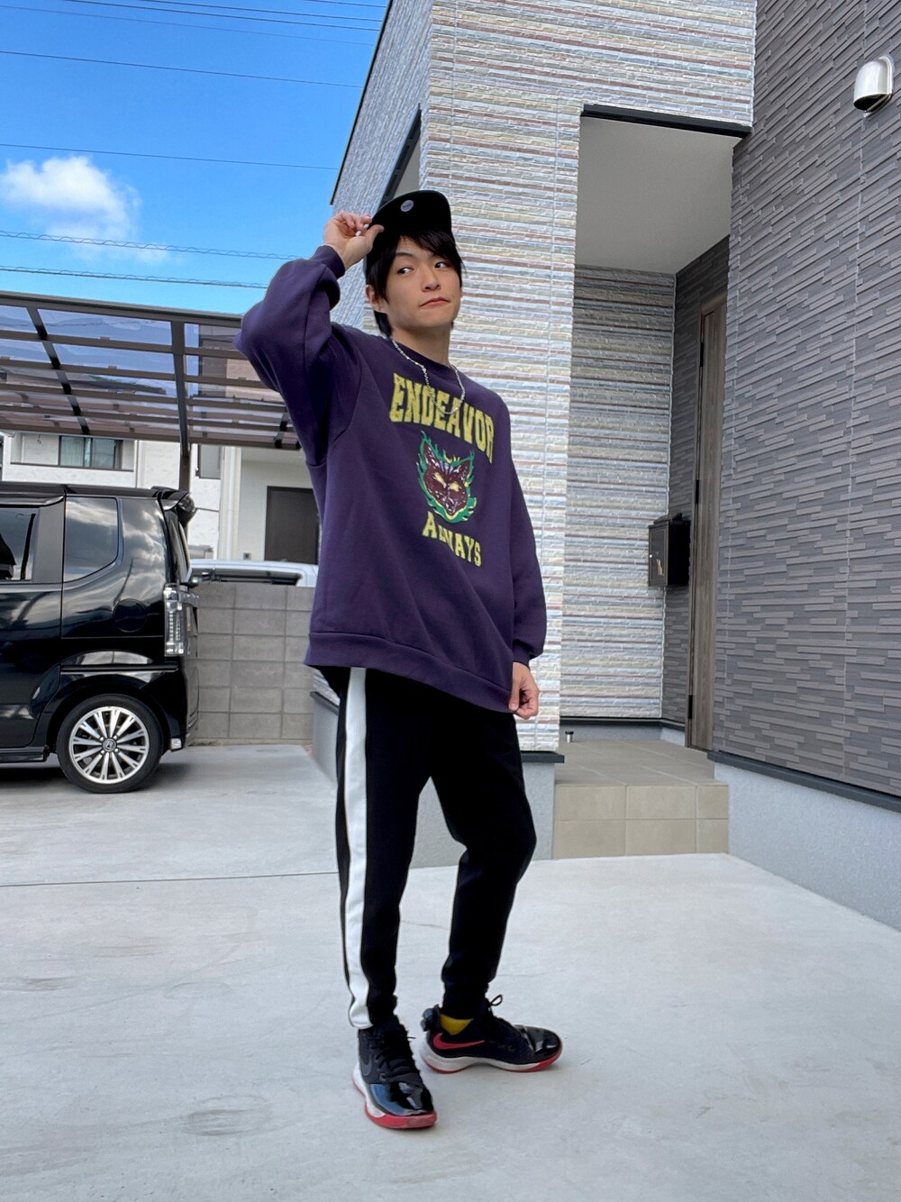 パープル系のスウェット、ブラック系のスウェットパンツ、ブラック系のスニーカーを着用したメンズの春コーディネートの1枚目の写真