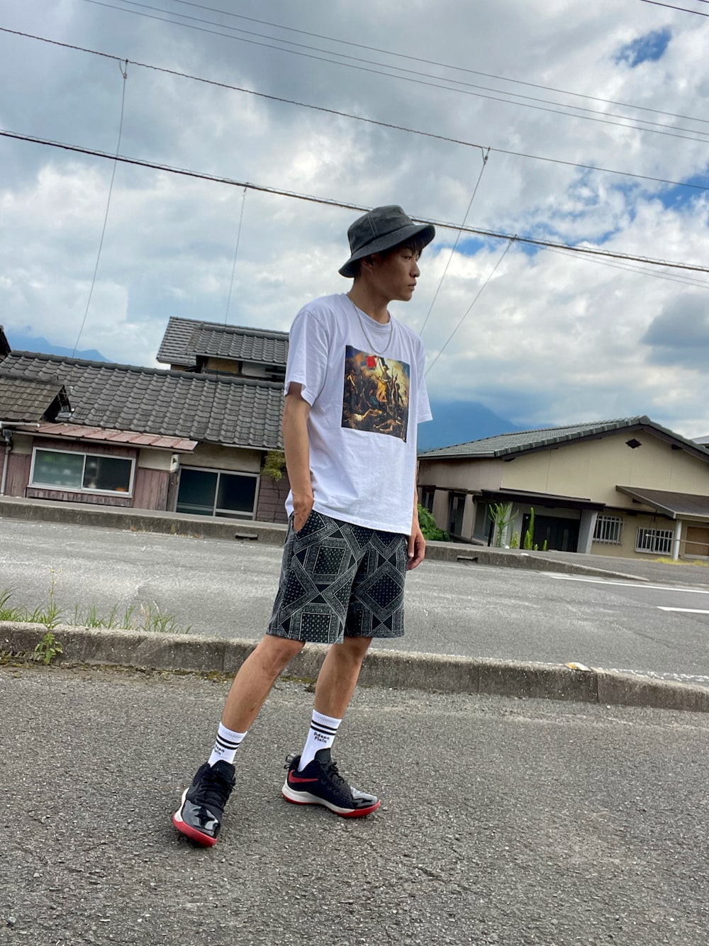 ホワイト系のTシャツ/カットソー、ブラック系のパンツ、ブラック系のスニーカーを着用したメンズの夏コーディネートの1枚目の写真