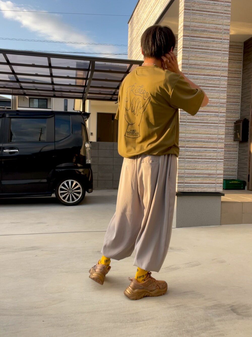 グリーン系のTシャツ/カットソー、ベージュ系のその他パンツ、ゴールド系のスニーカーを着用したメンズの秋コーディネートの1枚目の写真