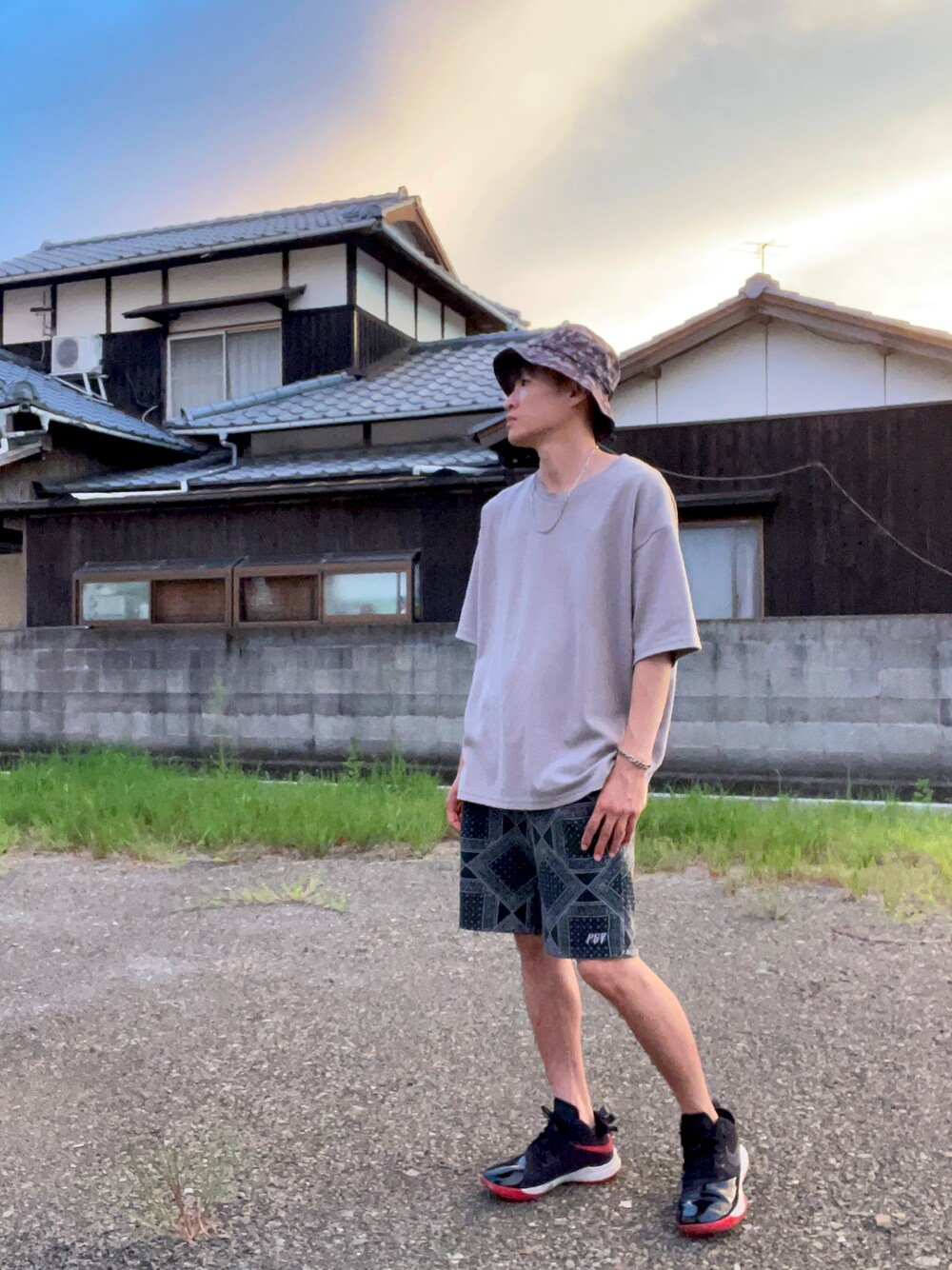 グレー系のTシャツ/カットソー、ブラック系のパンツ、ブラック系のスニーカーを着用したメンズの秋コーディネートの1枚目の写真