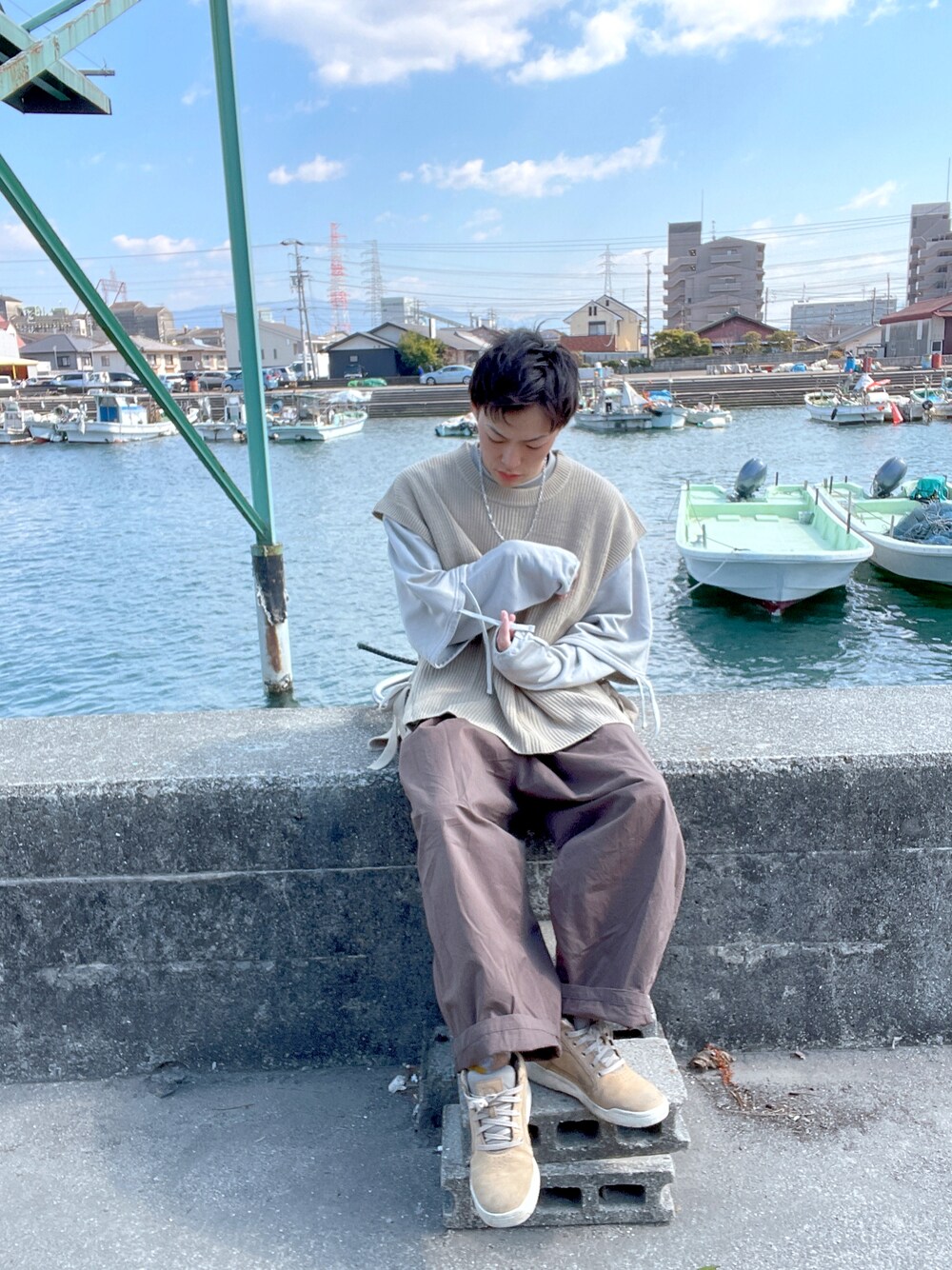 ベージュ系のベスト、ベージュ系のスウェット、ブラック系のその他パンツを着用したメンズの春コーディネートの1枚目の写真