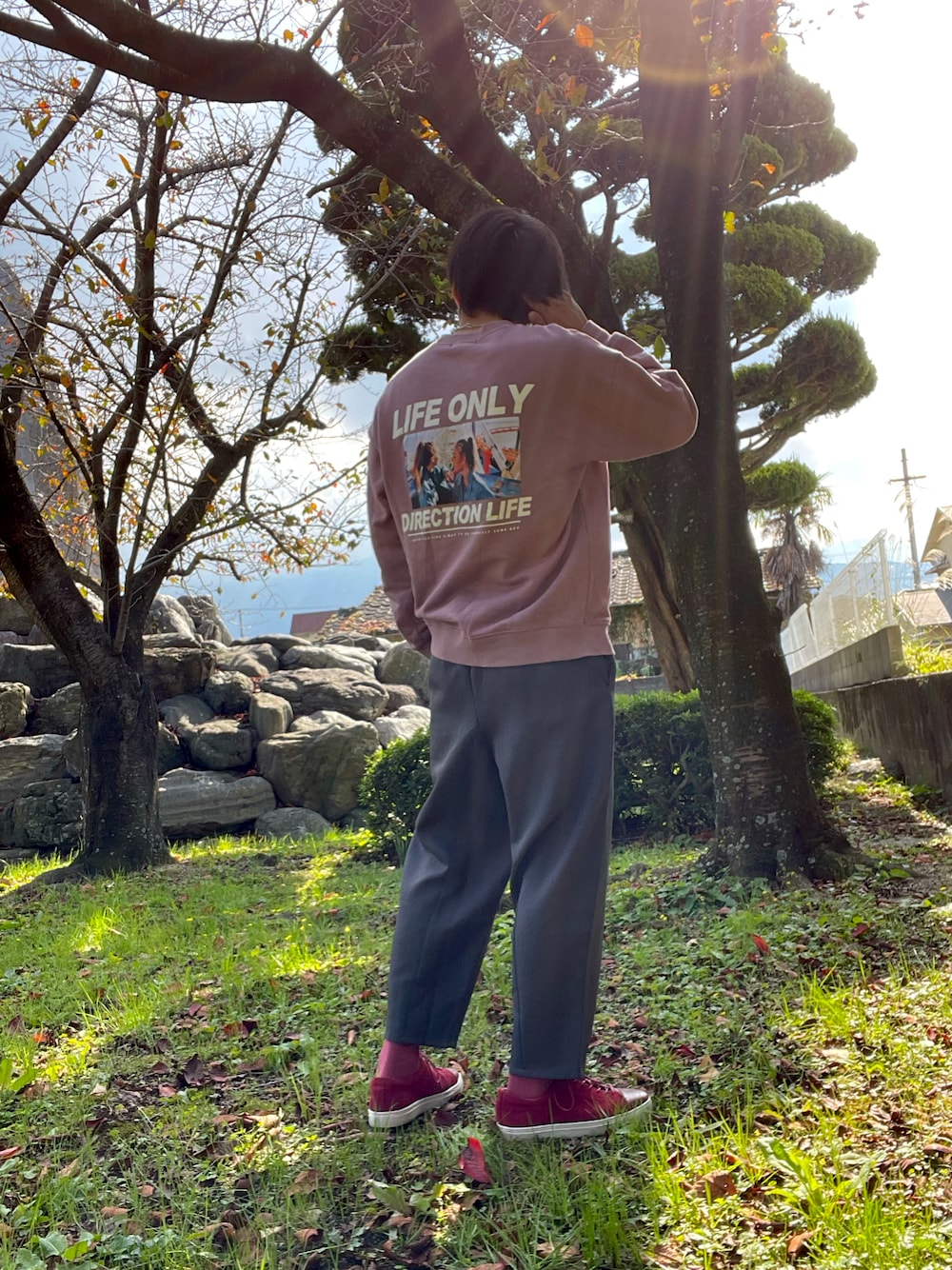 ピンク系のスウェット、グレー系のその他パンツ、レッド系のシューズを着用したメンズの秋コーディネートの1枚目の写真