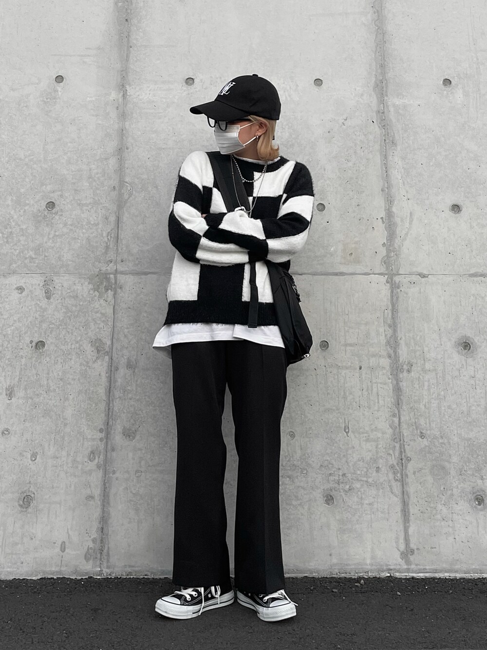 ブラック系のニット/セーター、ブラック系のショルダーバッグ、ブラック系のスラックスを着用したレディースの秋コーディネートの1枚目の写真