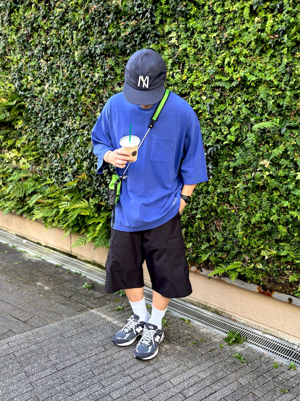 ブルー系のTシャツ/カットソー、ブラック系のパンツ、グリーン系のショルダーバッグを着用したメンズの夏コーディネートの1枚目の写真