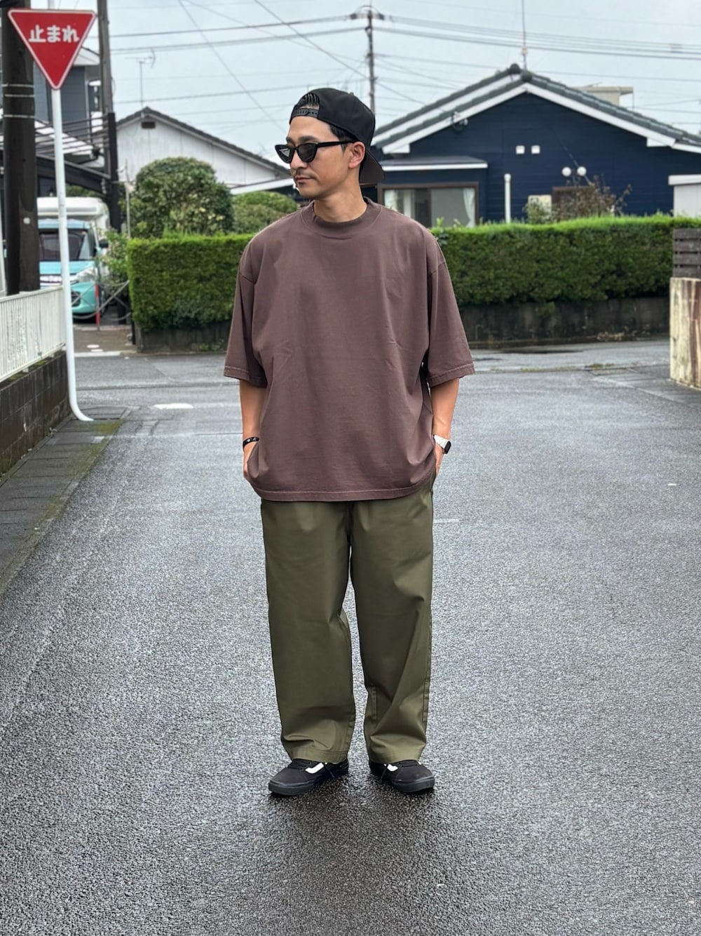 ブラック系のTシャツ/カットソー、グリーン系のチノパンツ、ブラック系のスニーカーを着用したメンズの秋コーディネートの1枚目の写真