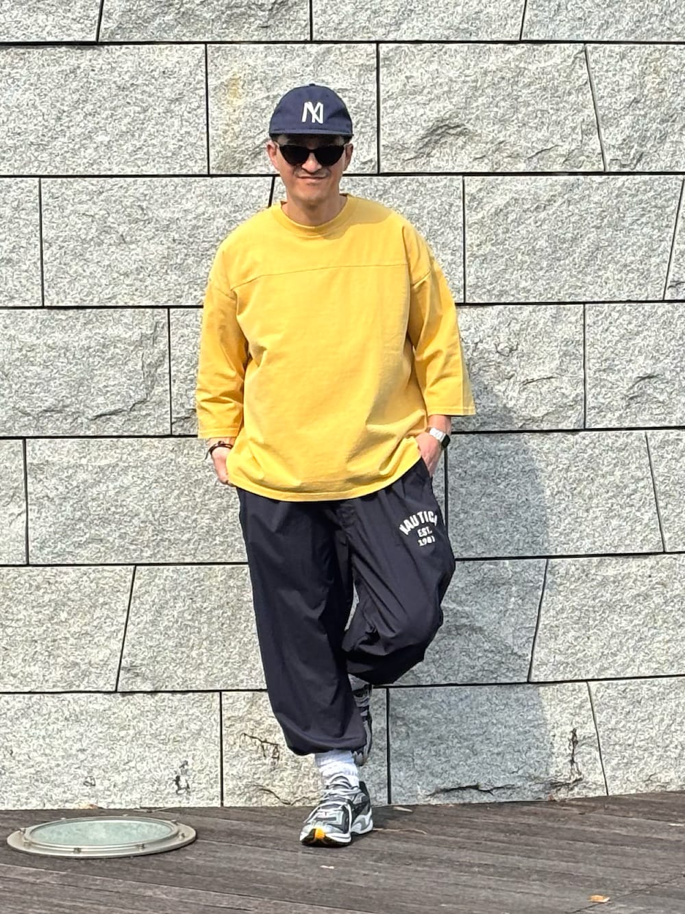 ブルー系のその他パンツ、イエロー系のTシャツ/カットソー、シルバー系のスニーカーを着用したメンズの春コーディネートの1枚目の写真
