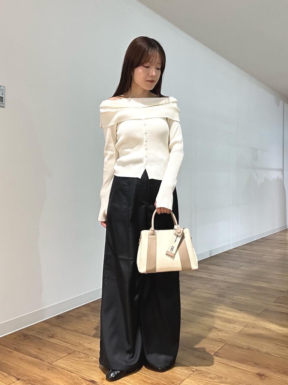 ホワイト系のニット/セーター、ブラック系のその他パンツ、ブラック系のパンプスを着用したレディースの春コーディネートの1枚目の写真